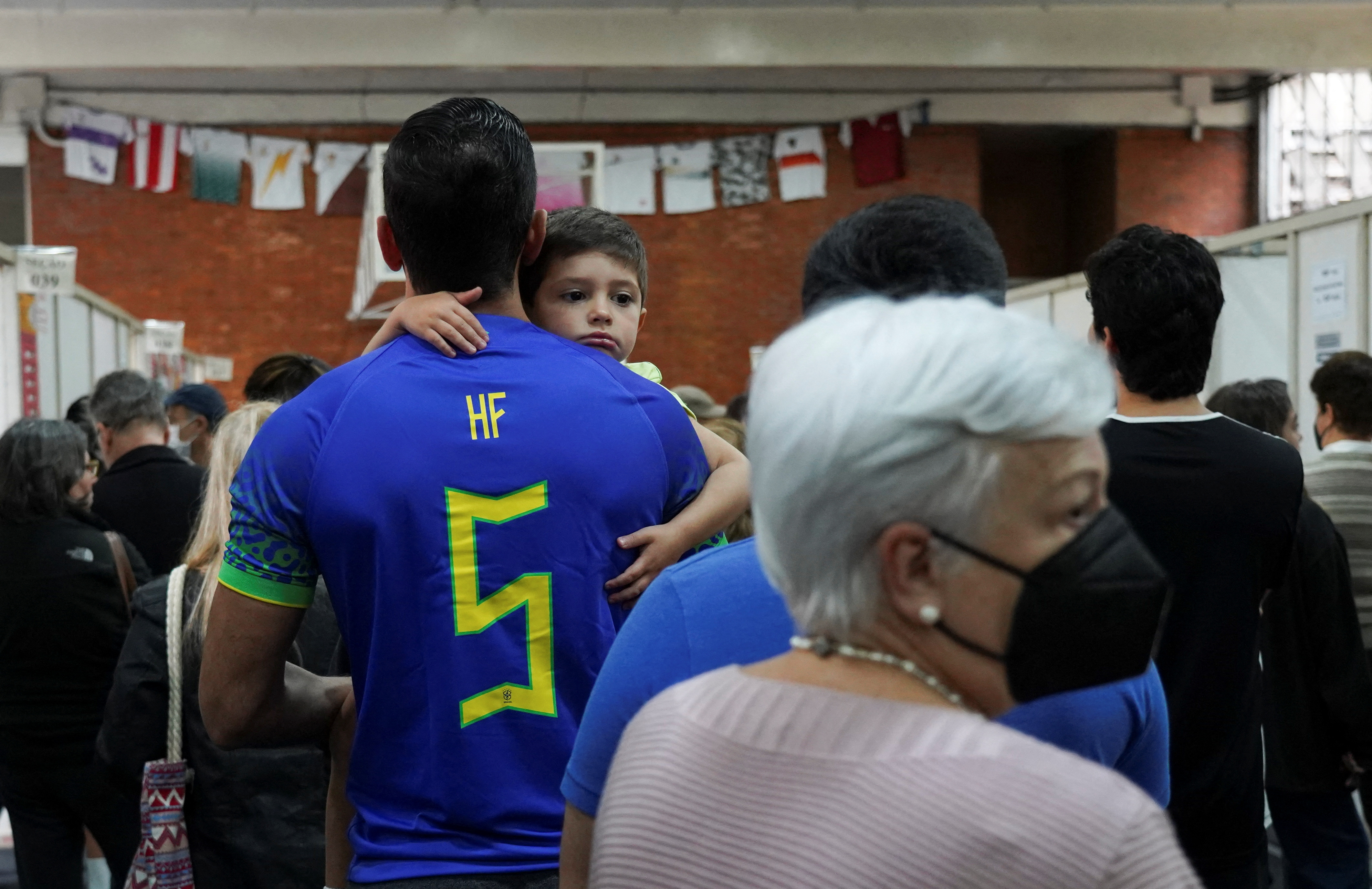 A person with a child in her arms waits to vote in São Paulo (REUTERS / Mariana Greif)