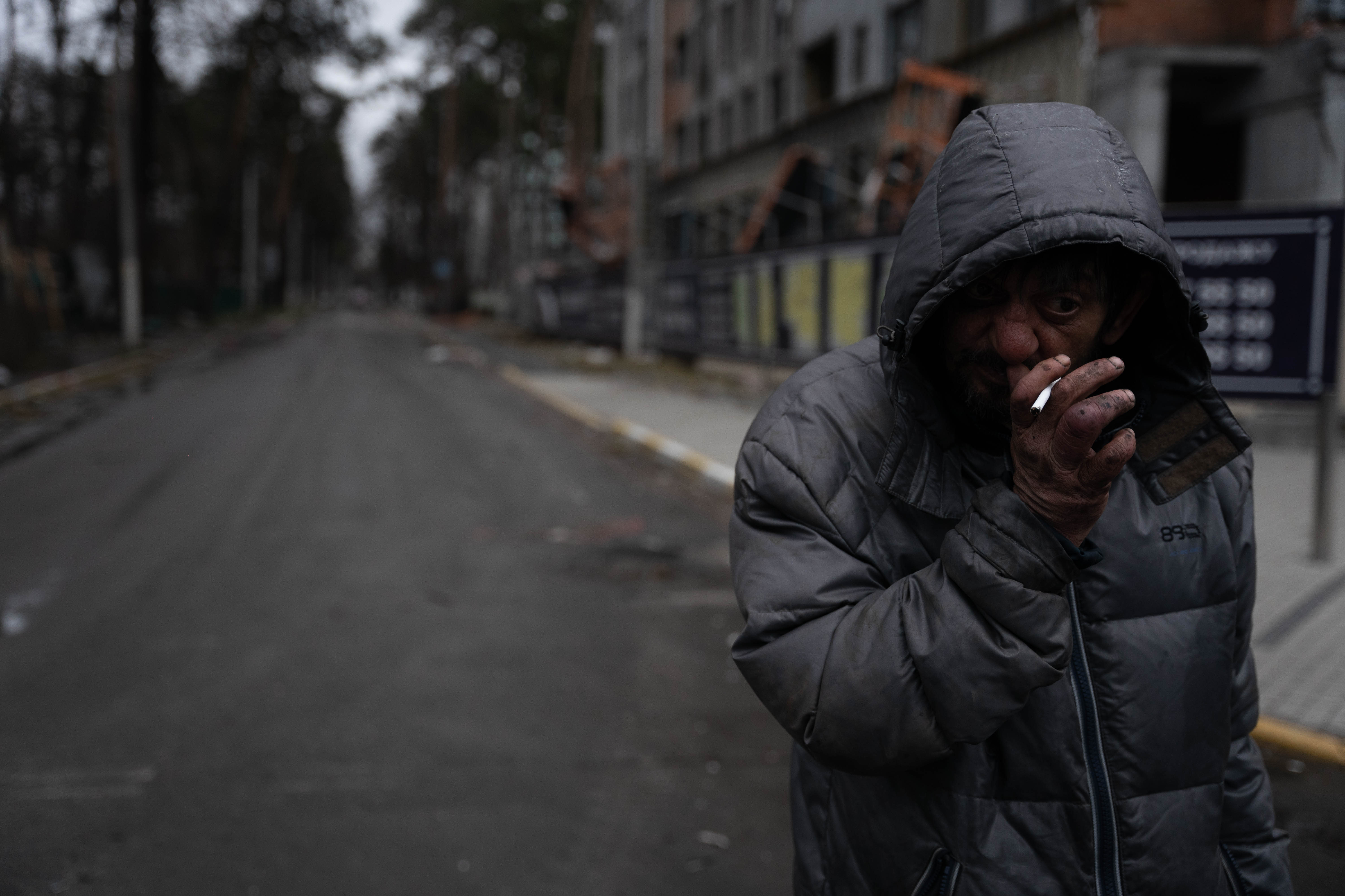 Un vecino de Irpin que regresa a la ciudad luego de estar viviendo en Kyiv debido a tener que abandonar su hogar ante la avanzada rusa, fuma en una de las calles desérticas. 