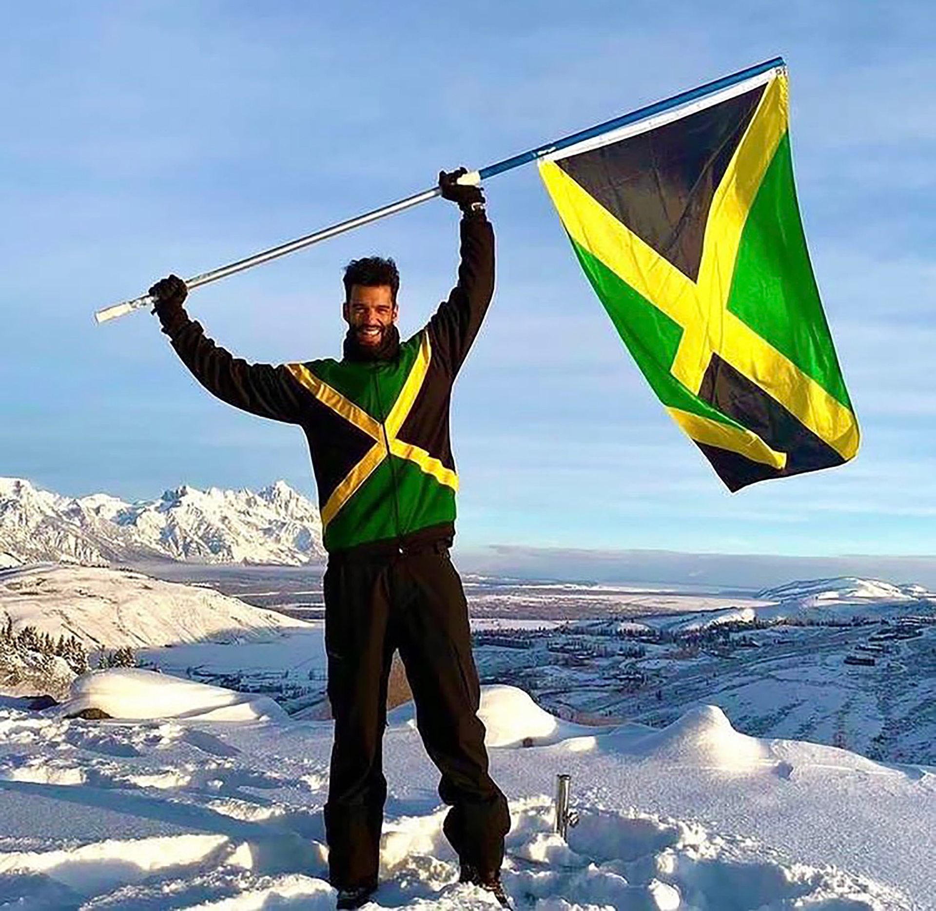Alexander proudly raises the Jamaican flag following his accomplishment (Alexander)