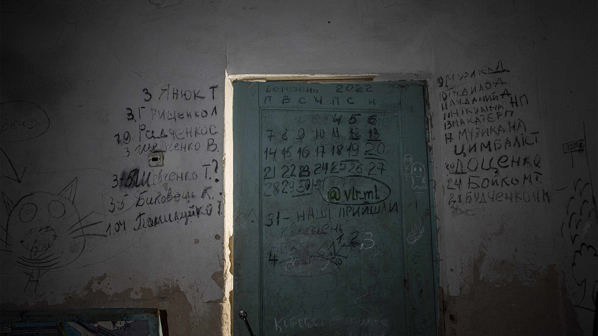 ARCHIVO - La escritura cubre una pared y una puerta en el sótano de una escuela en Yahidne, cerca de Chernihiv, Ucrania, el martes 12 de abril de 2022. Los lugareños dijeron que más de 300 aldeanos fueron forzados a entrar al sótano. Luego, durante semanas de estrés y privaciones, algunos comenzaron a morir. (Foto AP/Evgeniy Maloletka, archivo)