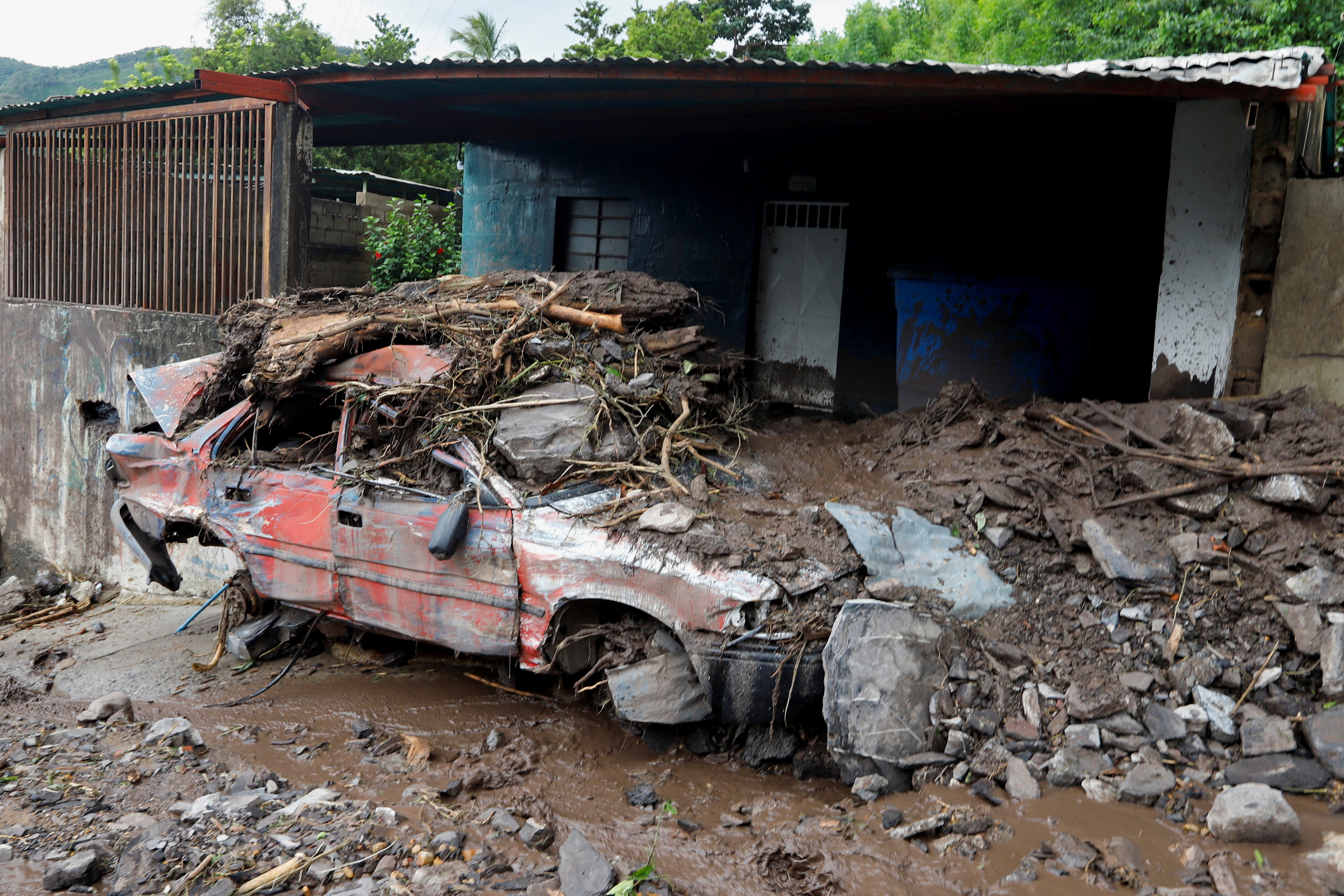 Un vehículo dañado cubierto de barro se muestra después de las inundaciones causadas por fuertes lluvias, en Puerto la Cruz