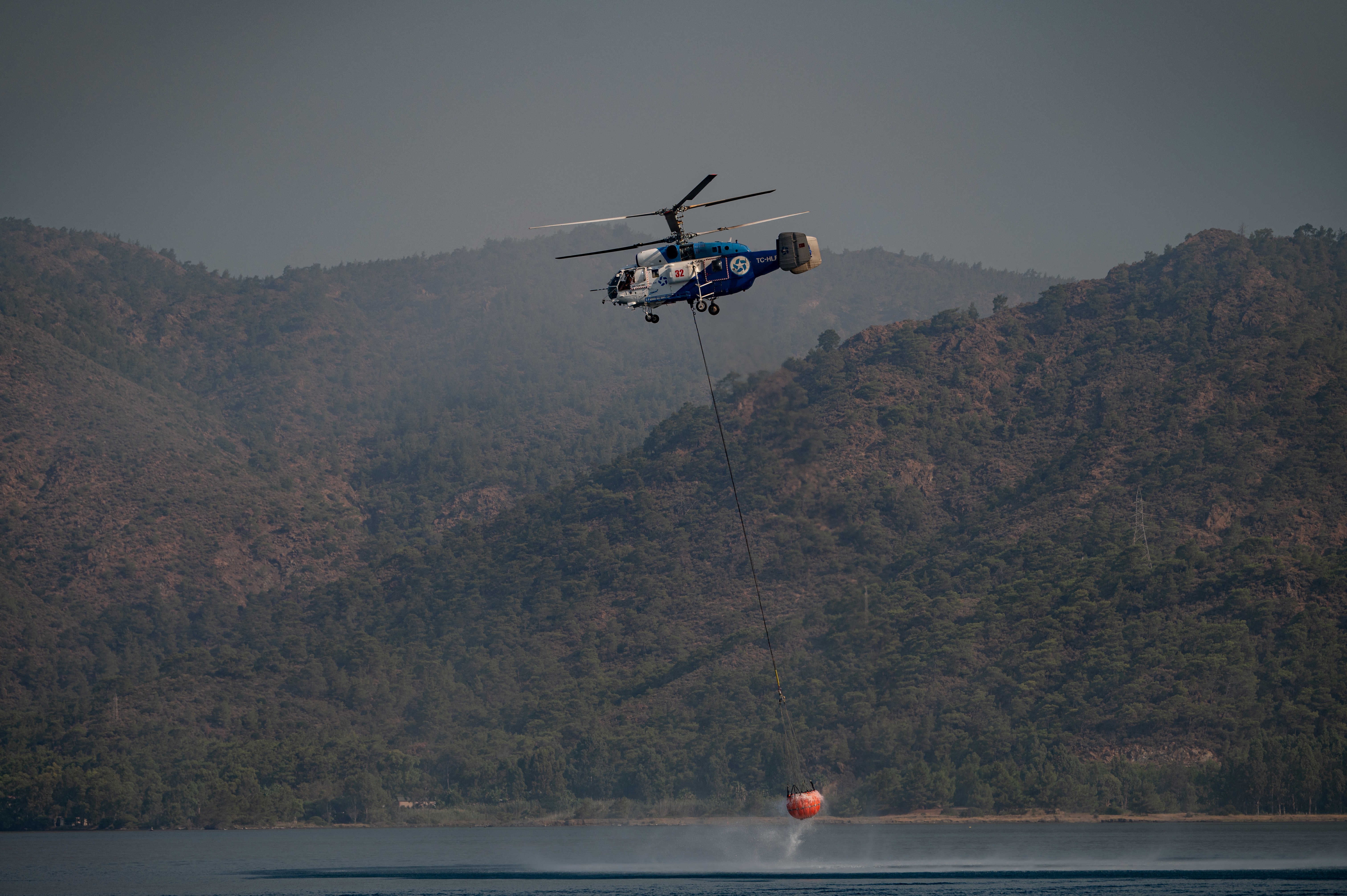 Un helicóptero de extinción de incendios carga agua el 2 de agosto de 2021 cerca de Marmaris.
 (Foto de Yasin AKGUL / AFP)
