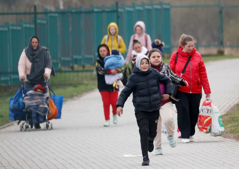 Refugiados ucranianos caminando luego de cruzar la frontera entre Ucrania y Polonia