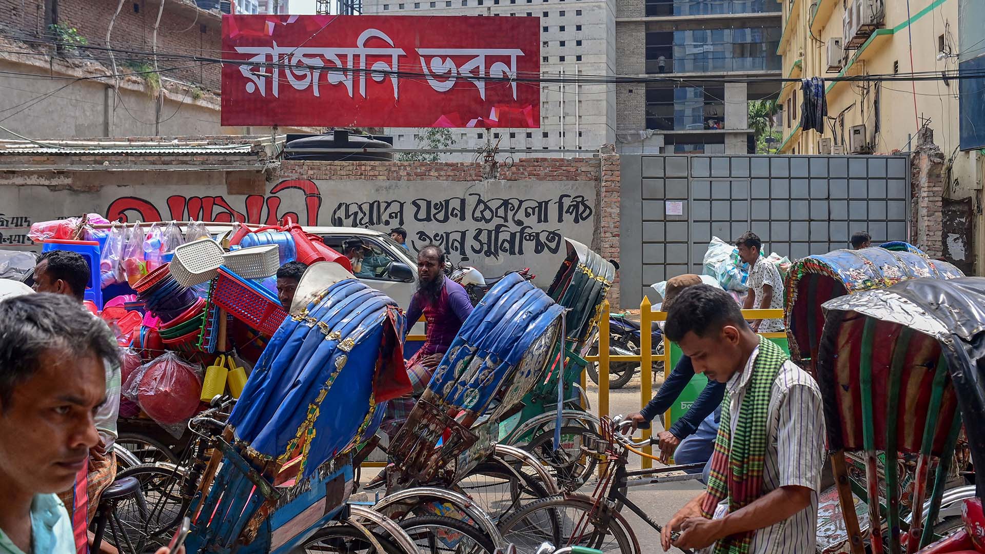 Rickshaw drivers wait outside an old movie theater in Dhaka (AFP)