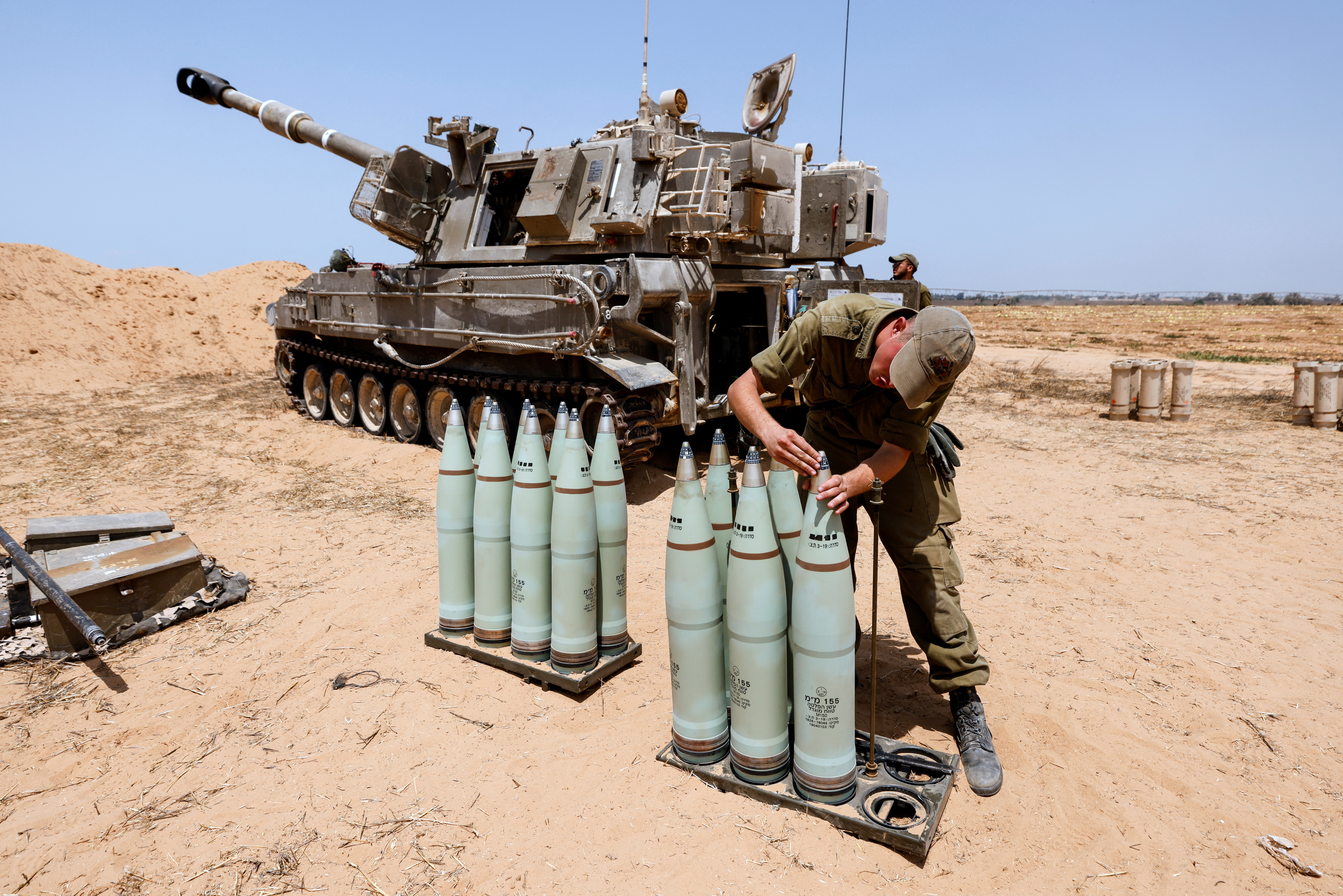 Un soldado israelí comprueba la munición junto a una unidad de artillería móvil en un campo en el lado israelí de la frontera con la Franja de Gaza el 6 de agosto de 2022 (Reuters)