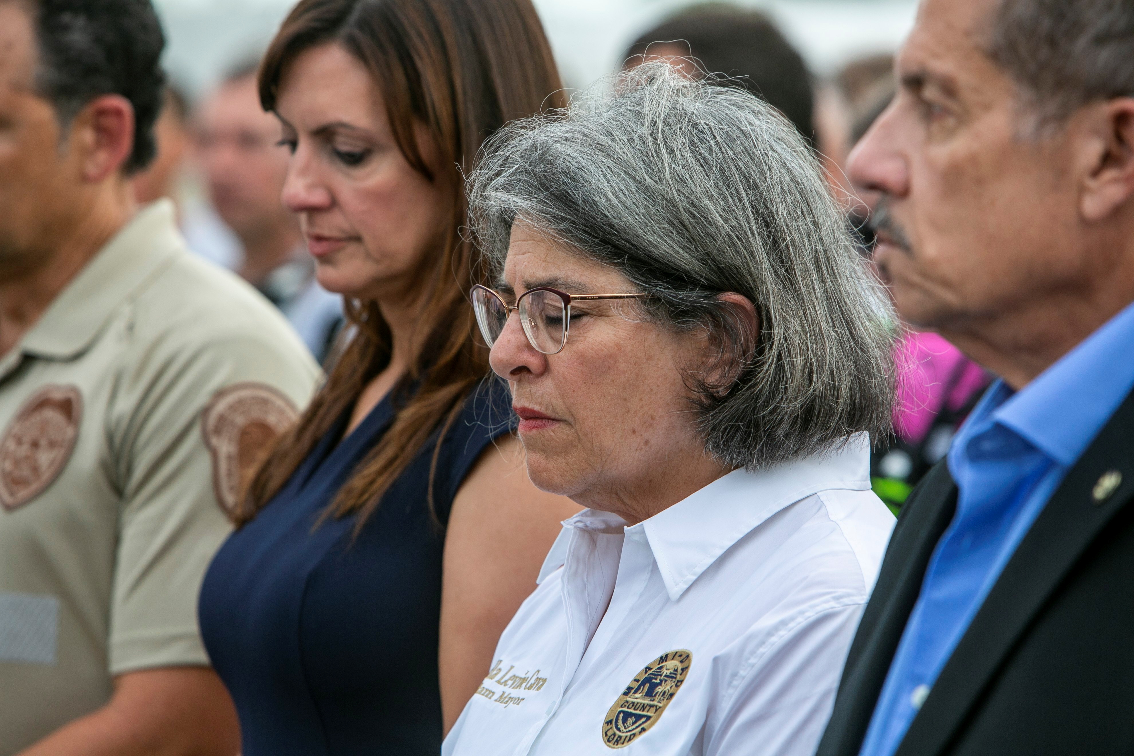 Miami-Dade County Mayor, Daniella Levine Cava  (center) prays along with other officials in front of the rubble that once was Champlain Towers South during a prayer ceremony and a moment of silence in Surfside, Florida, U.S. July 7, 2021. Jose A Iglesias/Pool via REUTERS