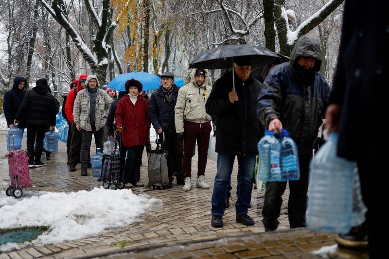 Residentes locales hacen fila para rellenar botellas con agua en Kiev (Reuters)