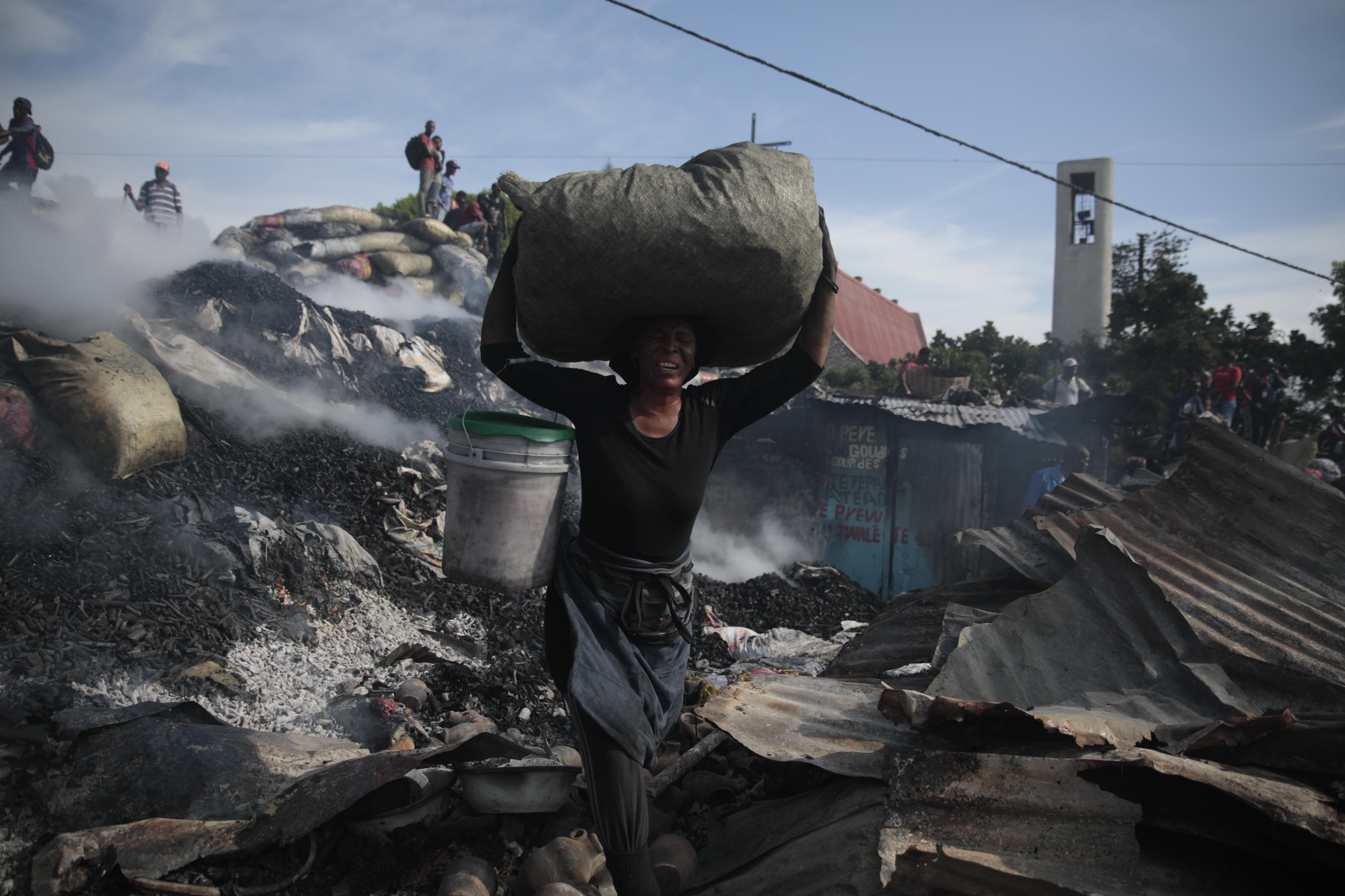 A vendor salvages merchandise from the burned-out ruins of the Shada market, in the Petion-ville area of ​​Port-au-Prince, Haiti, on May 4, 2023. (AP Photo/Odelyn Joseph)