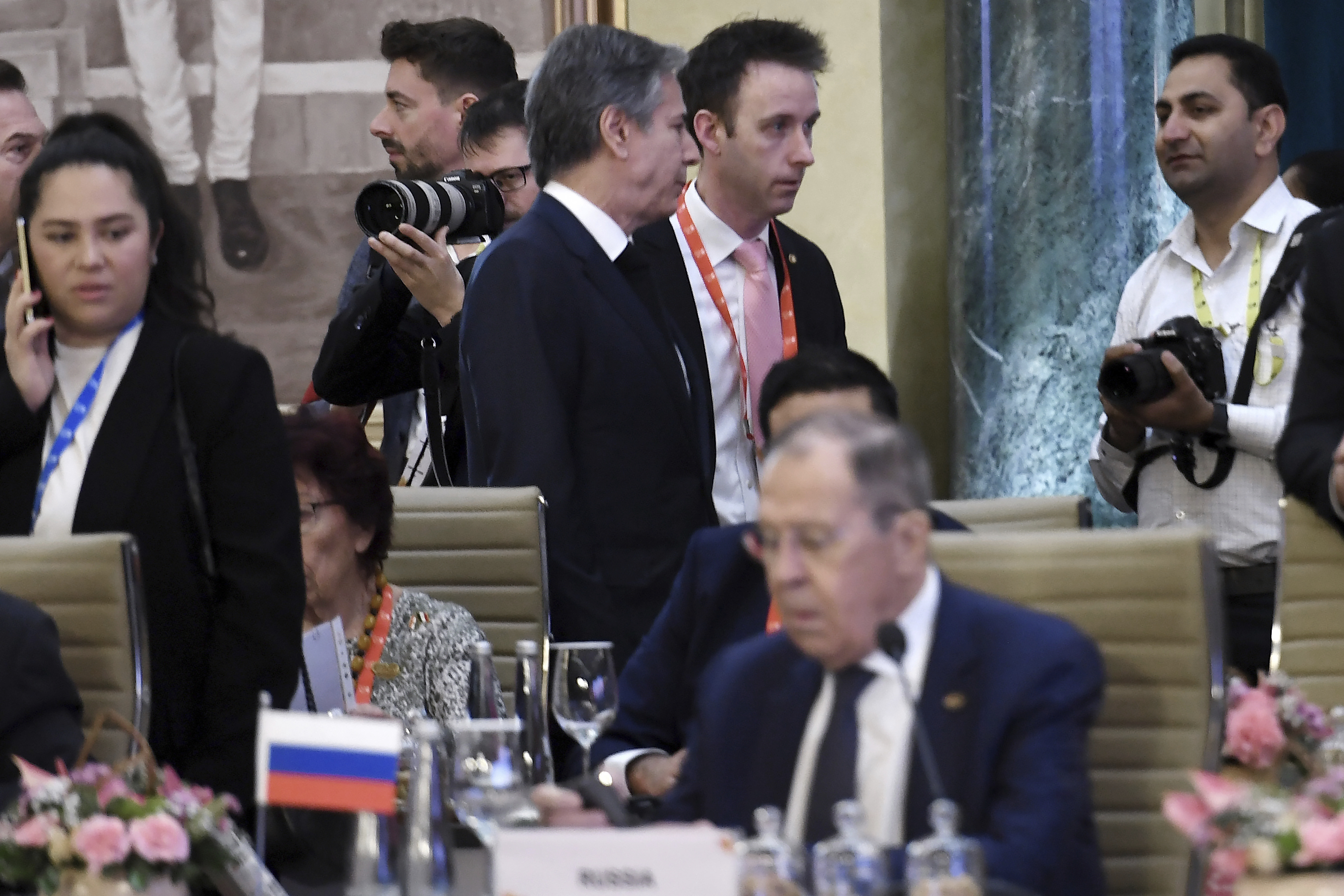 El secretario de Estado de Estados Unidos, Antony Blinken (centro, arriba), pasa junto al ministro de Exteriores de Rusia, Sergéi Lavrov, durante una reunión de cancilleres del Grupo de los 20 en Nueva Delhi, en India  (Olivier Douliery/Pool Foto vía AP)