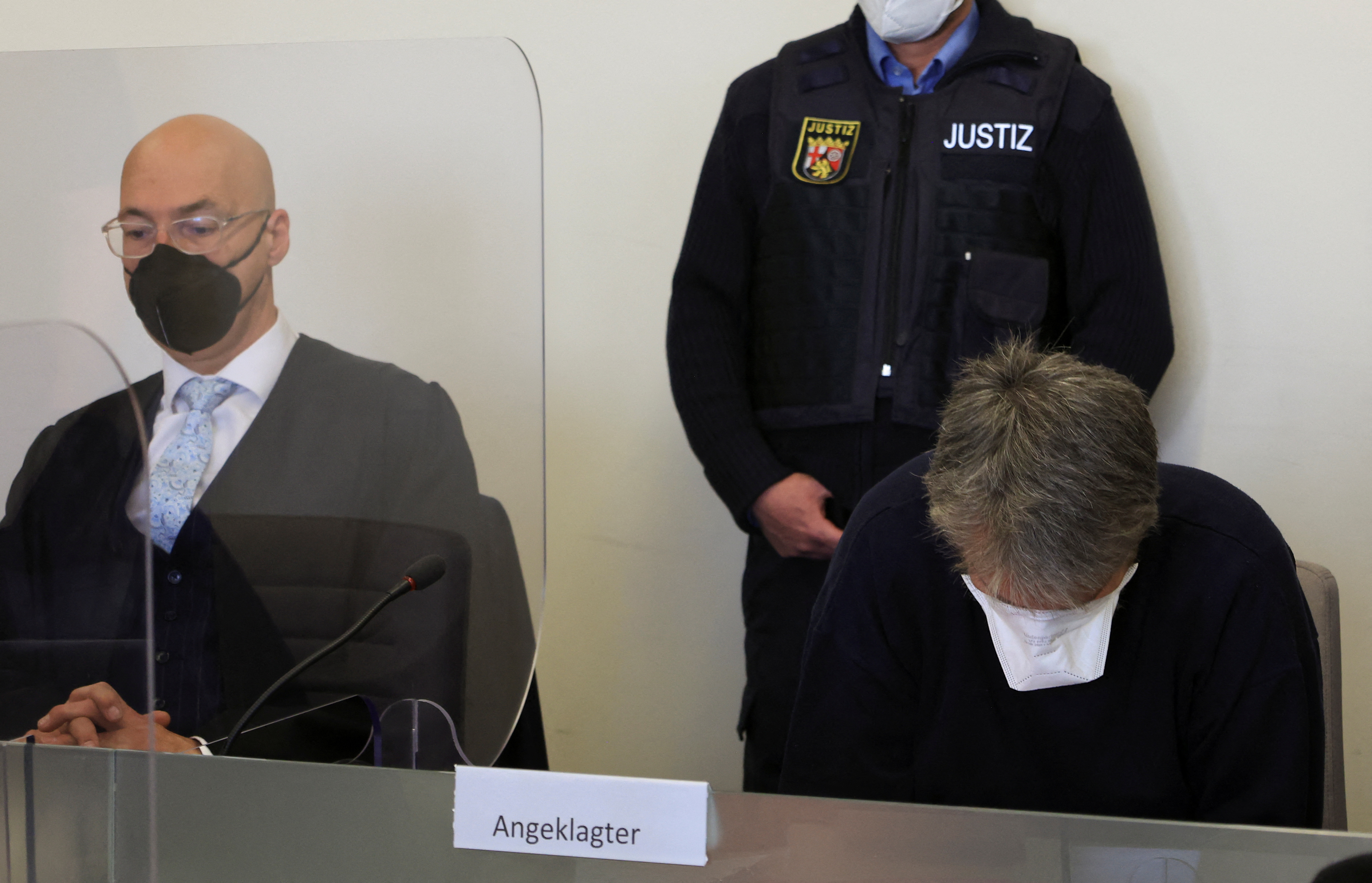 El hombre de 50 años acusado de haber matado a un empleado de gasolinera de 20 años, el 18 de septiembre de 2021, en Idar-Oberstein, se sienta con una máscara facial en un tribunal local junto con su abogado Alexander Klein en Bad Kreuznach, Alemania, el 21 de marzo de 2022. REUTERS/Wolfgang Rattay/Archivo