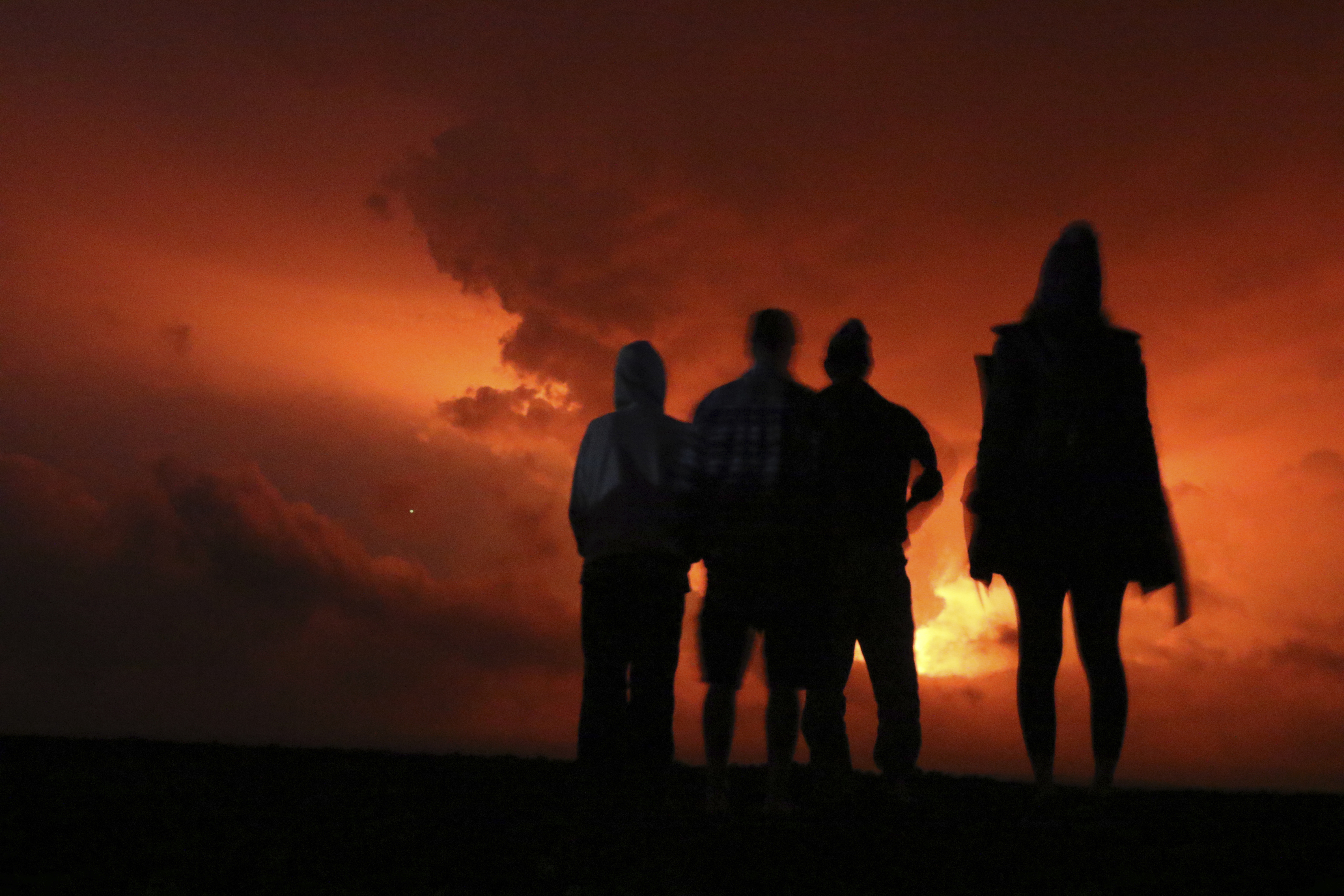 La gente observa el resplandor de la lava que brota del volcán Mauna Loa de Hawái, (Foto AP/Caleb Jones)