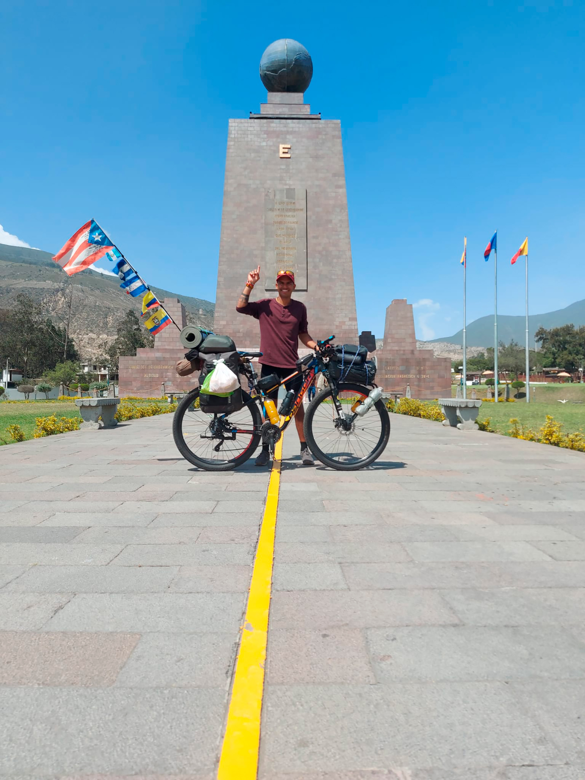 Con su bicicleta en Quito, en el hito de la línea del Ecuador