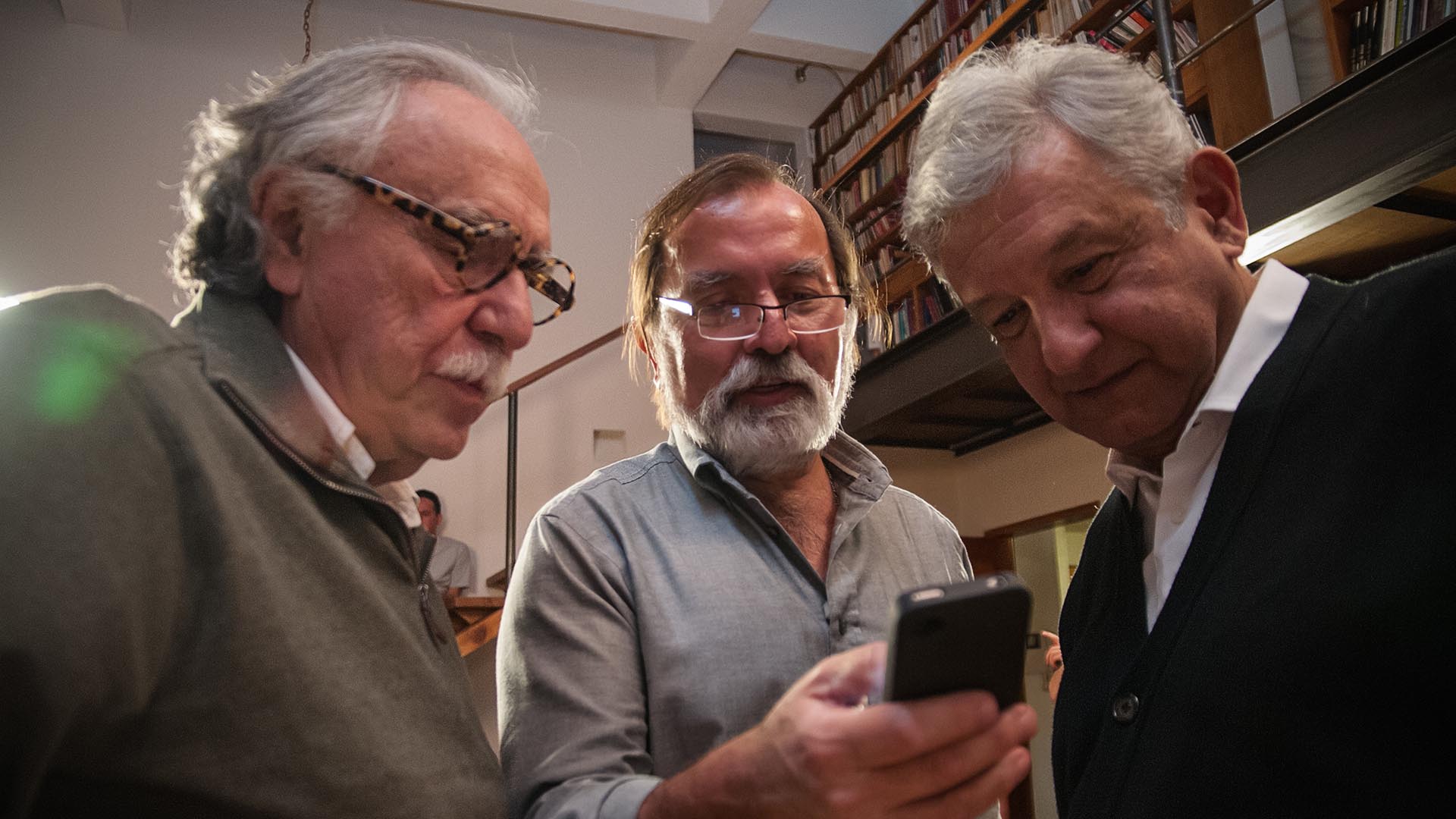 Epigmenio Ibarra le muestra en su teléfono una escena de su documental al presidente López Obrador, mientras Carlos Payán observa (ENEAS)