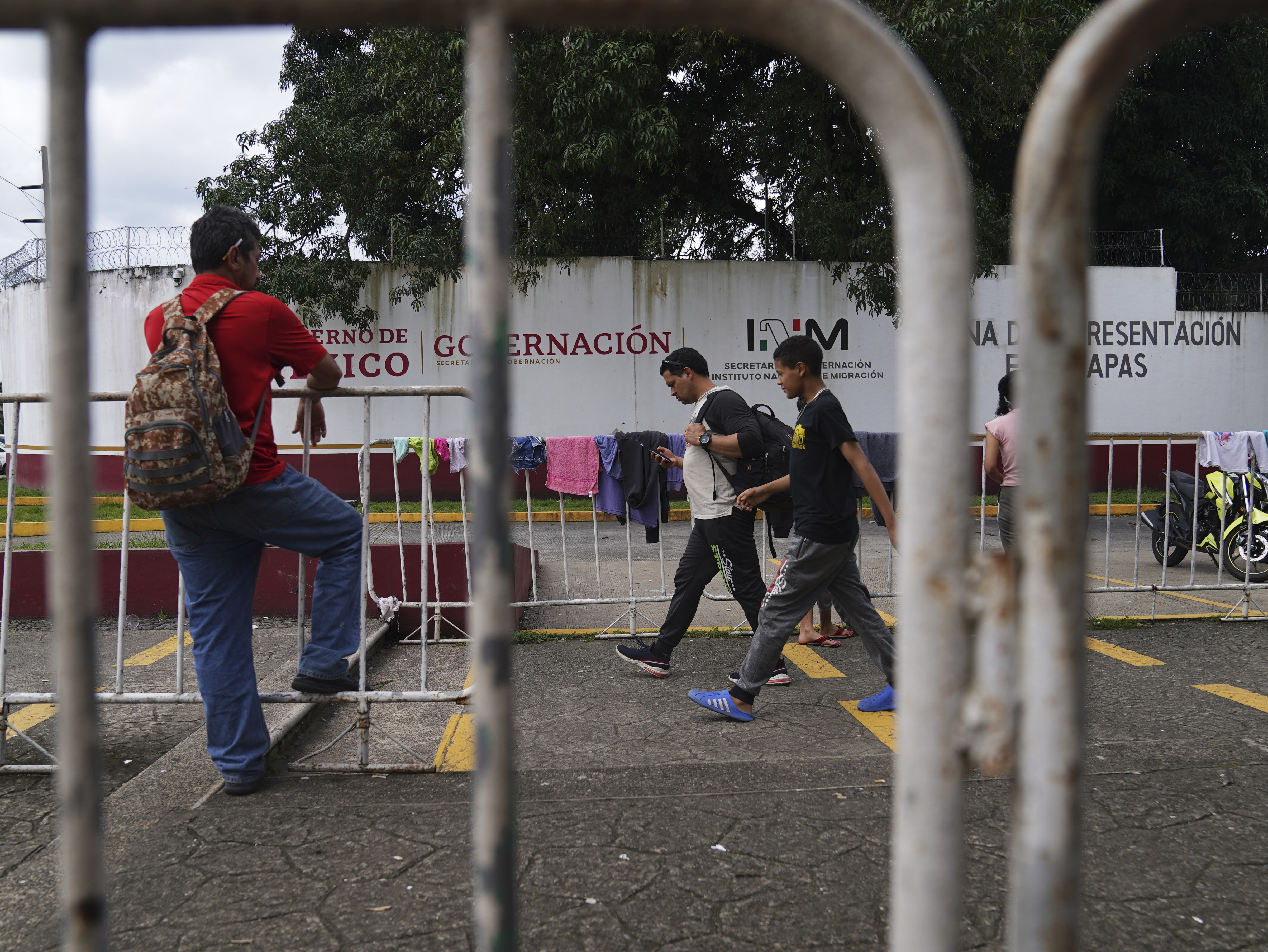 Migrantes caminan frente al Instituto Nacional de Migración en Tapachula, estado de Chiapas. (AP Foto/Marco Ugarte)