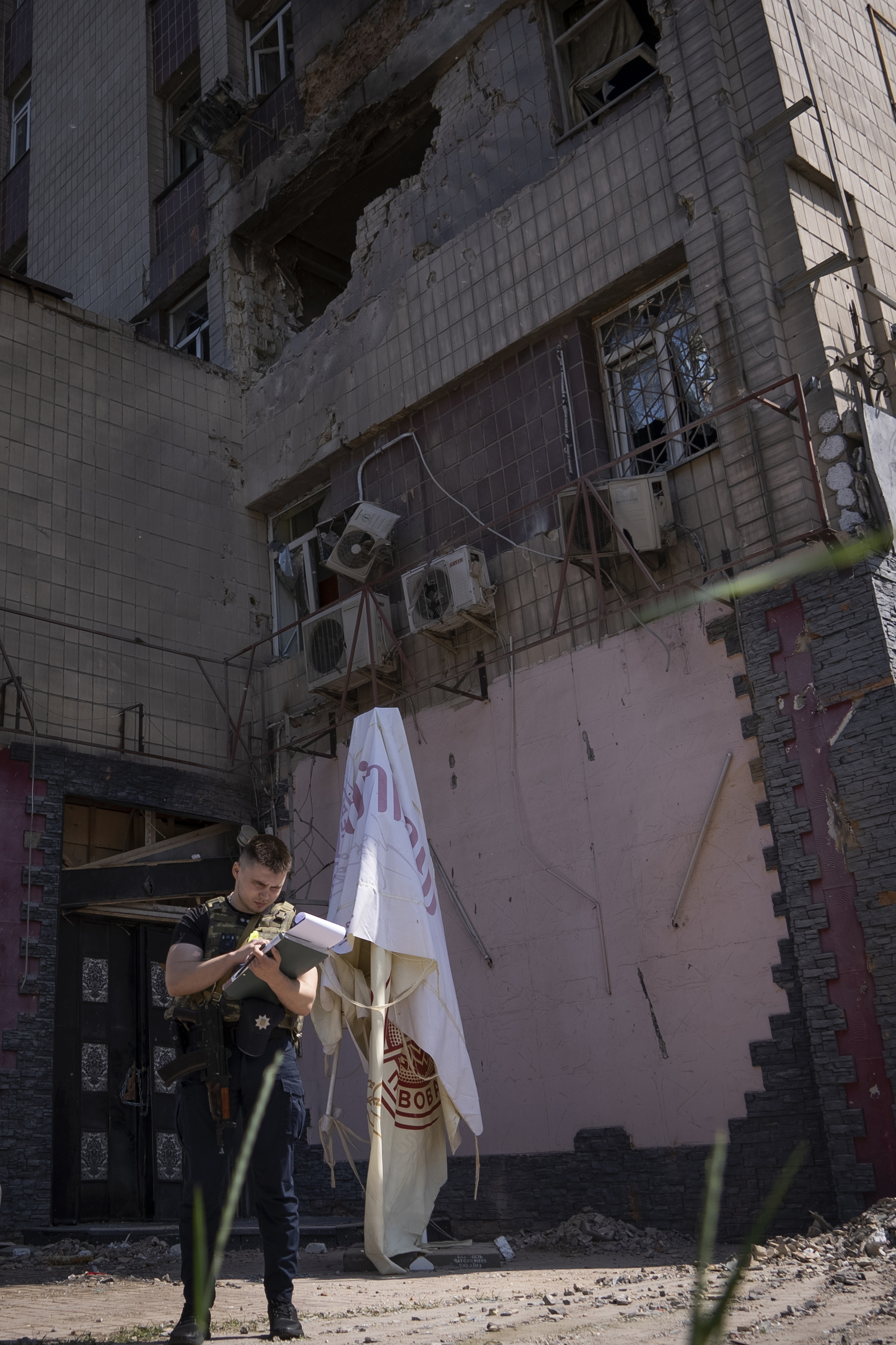 La policía inspecciona un edificio de apartamentos dañado por un dron durante un ataque nocturno en Kiev, Ucrania, el domingo 28 de mayo de 2023.  (Foto AP/Vasilisa Stepanenko)

