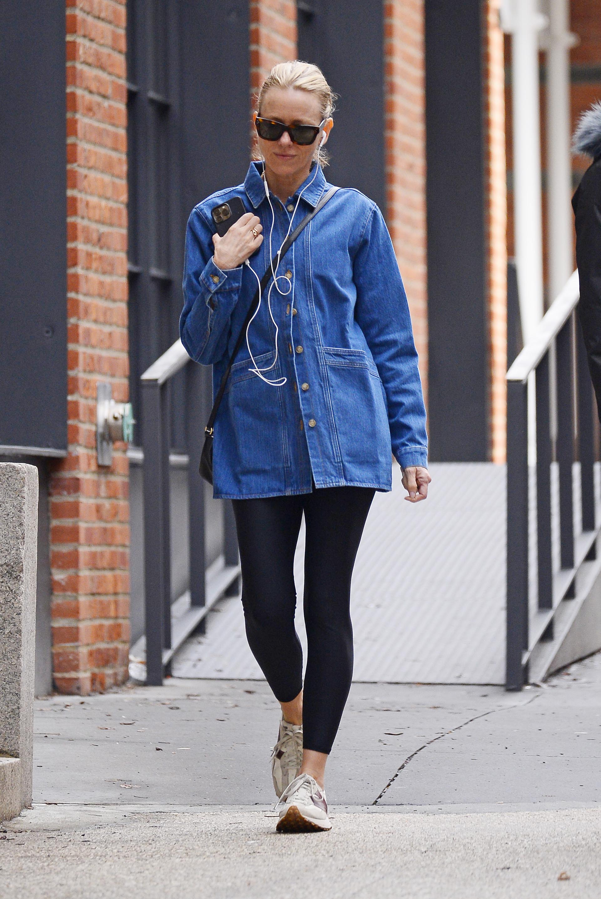 Naomi Watts fue fotografiada mientras daba un paseo por las calles de Nueva York. Lució unas calzas negras, una camisa de jean, zapatillas cómodas y aprovechó la oportunidad para escuchar música desde su teléfono mientras caminaba. Además, llevó puestos lentes de sol