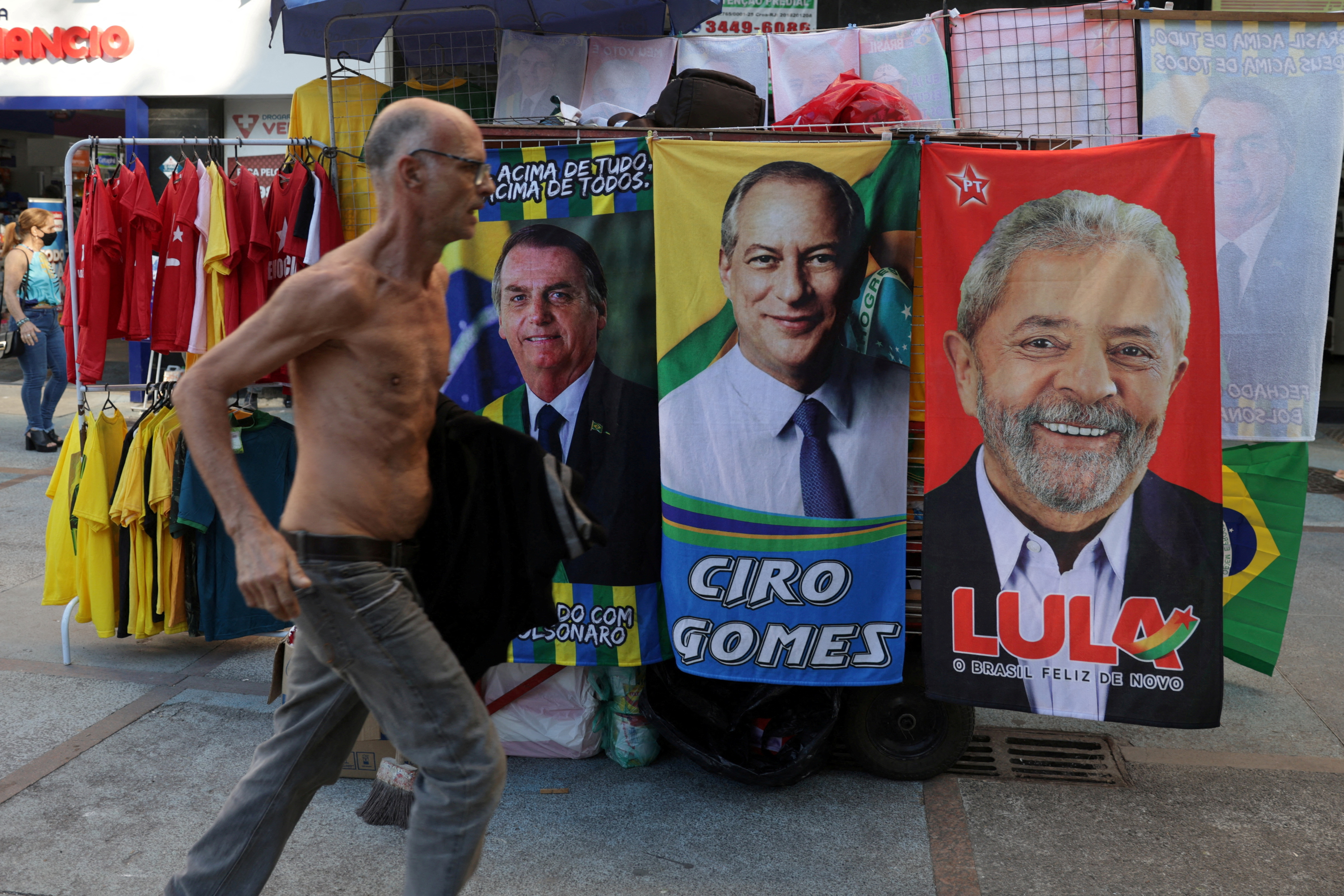 FOTO DE ARCHIVO: Un hombre corre junto a pancartas con fotos de los candidatos presidenciales brasileños: Jair Bolsonaro, Ciro Gomes y Luiz Inácio Lula da Silva, en Río de Janeiro, el pasado 1 de septiembre de 2022 (Reuters)