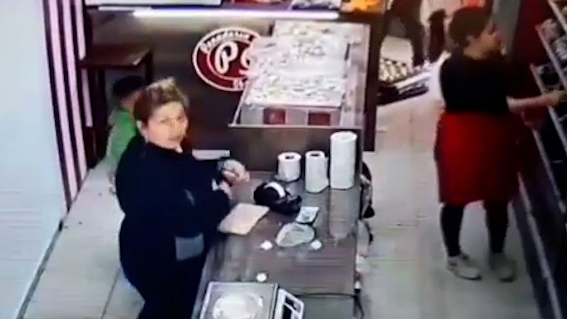 El momento en el que la ladrona observa la cámara de seguridad en una panadería de San Juan, pero igualmente lleva a cabo el robo de las propinas.