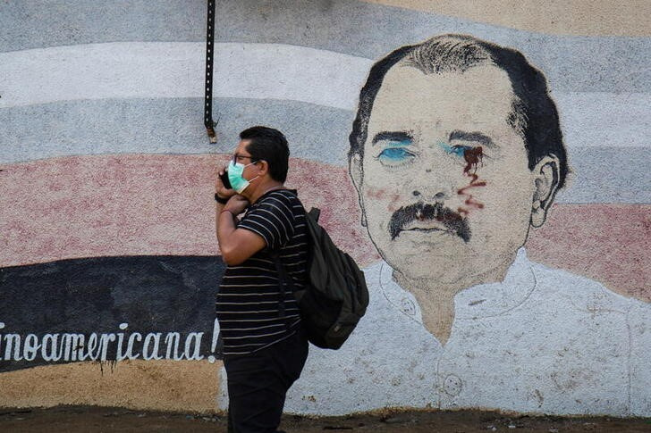 Una persona pasando frente a un mural con la imagen de Daniel Ortega en Managua (REUTERS/Maynor Valenzuela)