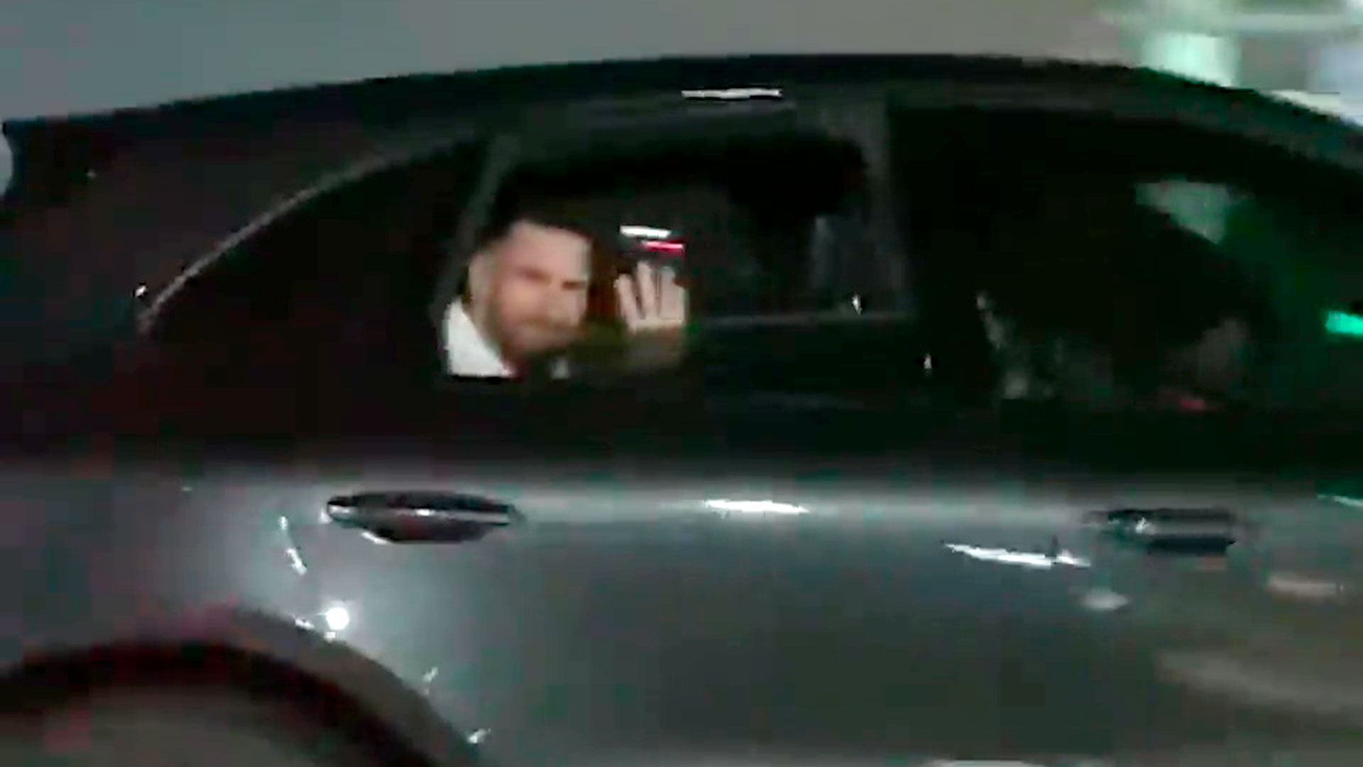 Lionel Messi saluda desde el auto a una fanática.