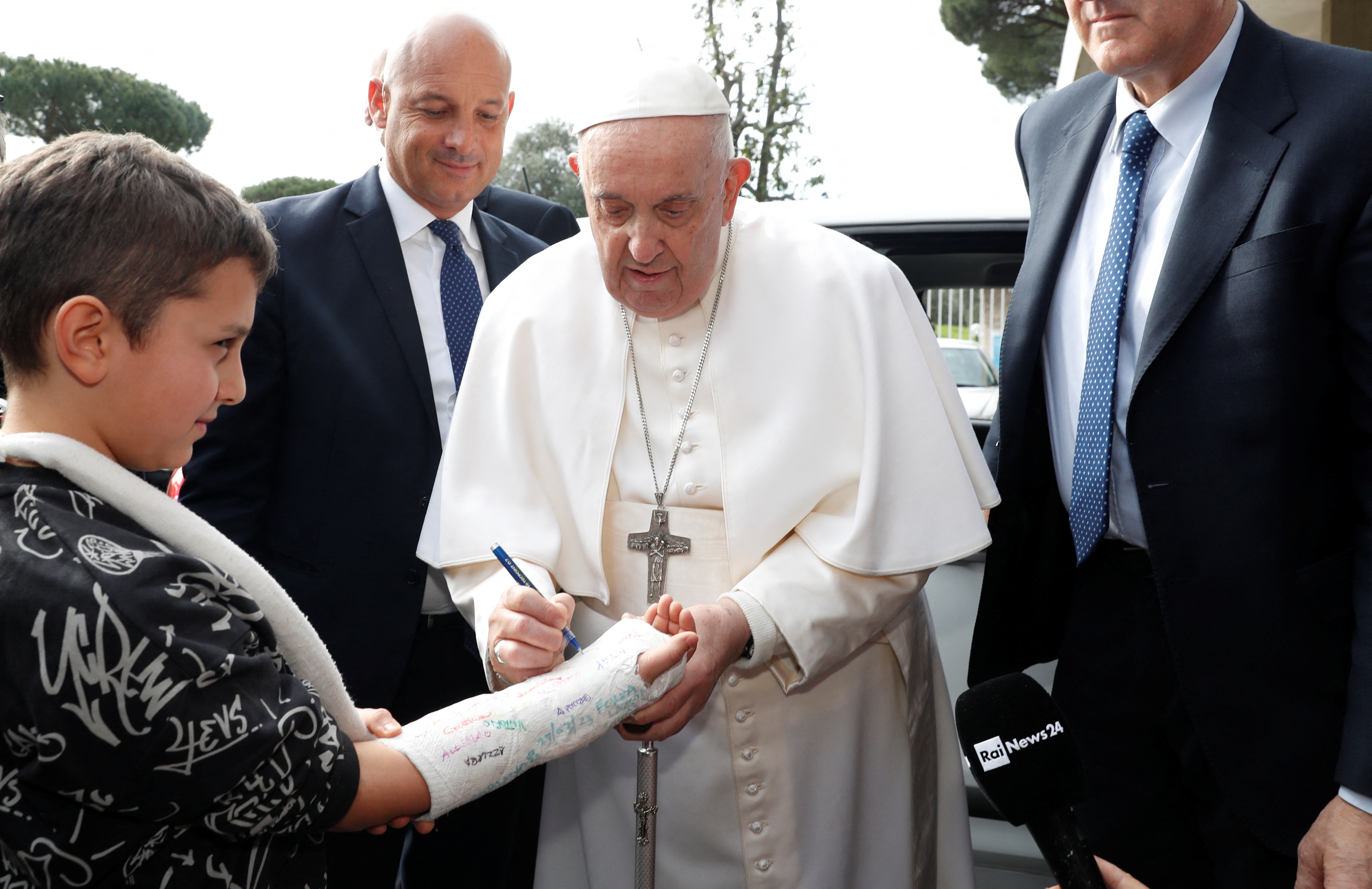 El papa Francisco escribe en yeso de un niño a su salida del hospital Gemelli de Roma, Italia, 1 de abril de 2023. REUTERS/Remo Casilli