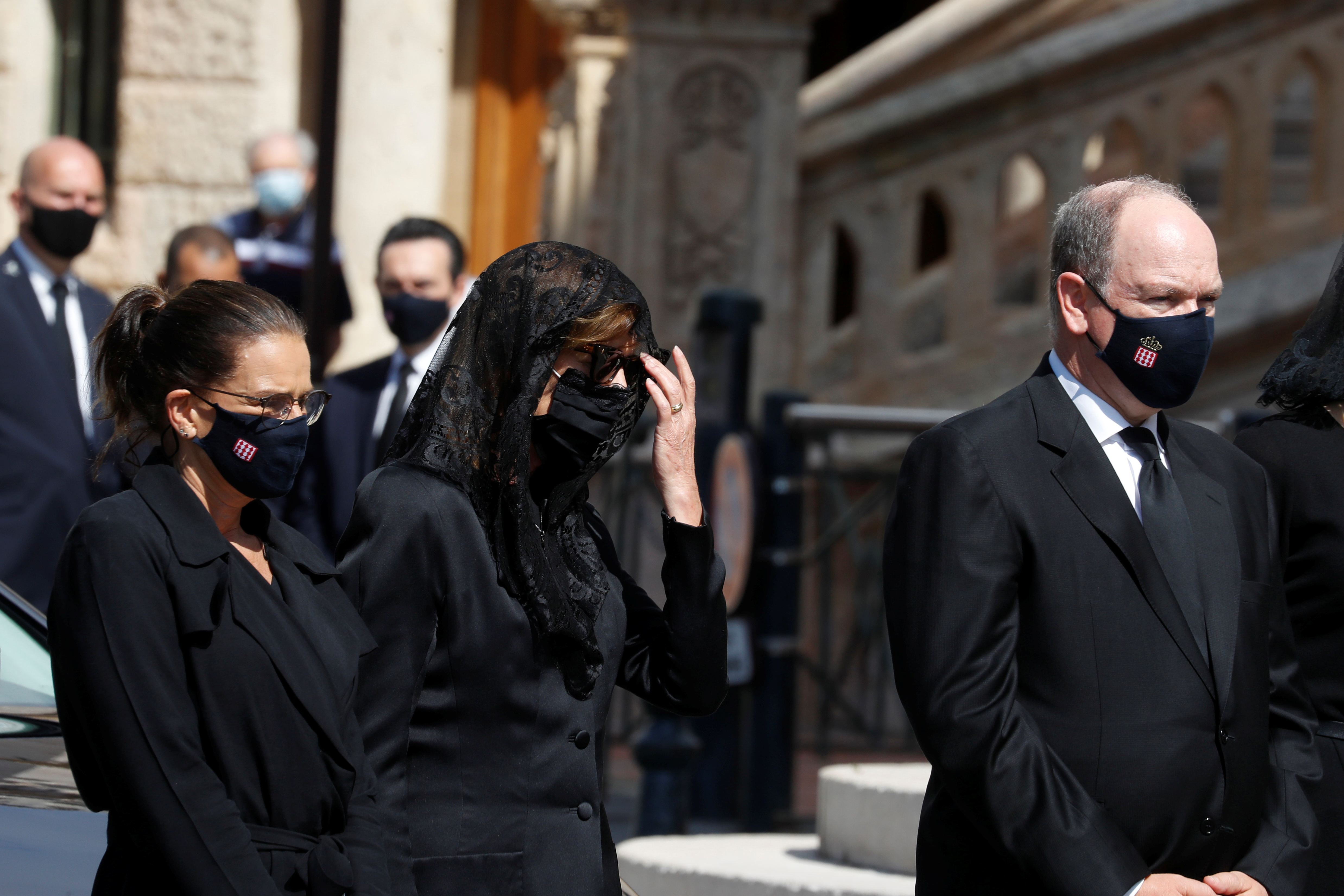 De estricto luto y con mascarilla negra incluida, Alberto de Mónaco junto a sus hermanas, las princesas Estefanía y Carolina, durante el funeral de la baronesa Elizabeth-Ann de Massy, en la Catedral del Principado (Reuters)