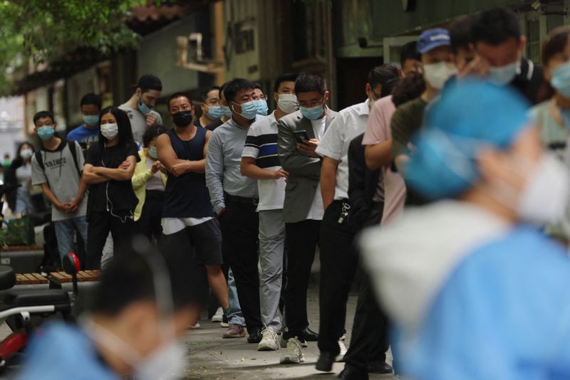 La gente hace cola para someterse a una prueba de ácido nucleico en un puesto de pruebas móvil, tras el brote de la enfermedad por coronavirus (COVID-19), en Pekín, China. 13 de junio de 2022. REUTERS/Tingshu Wang