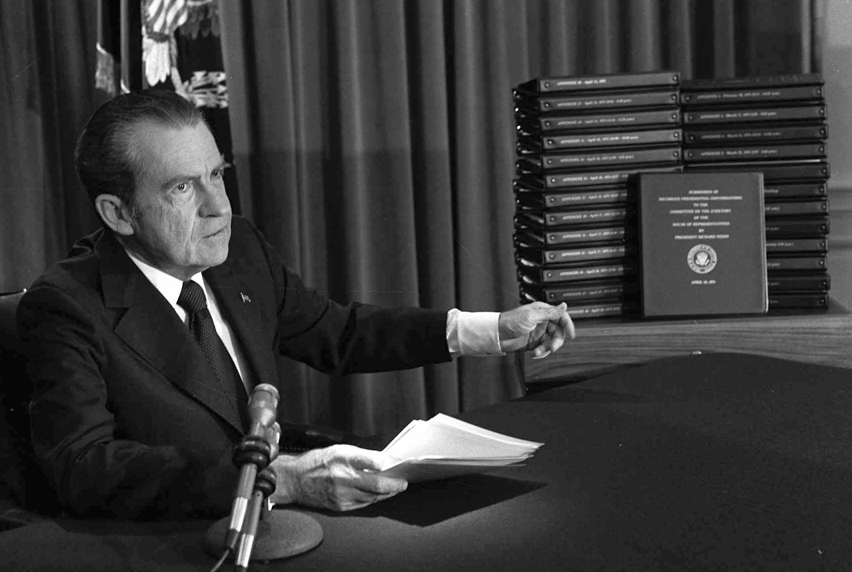 El presidente Richard Nixon muestra transcripciones de grabaciones de audio de la Casa Blanca después de que en un discurso televisado a la nación anunció que entregaría las transcripciones a investigadores de la Cámara de Representantes sobre el caso Watergate, el 29 de abril de 1974, en Washington (AP)