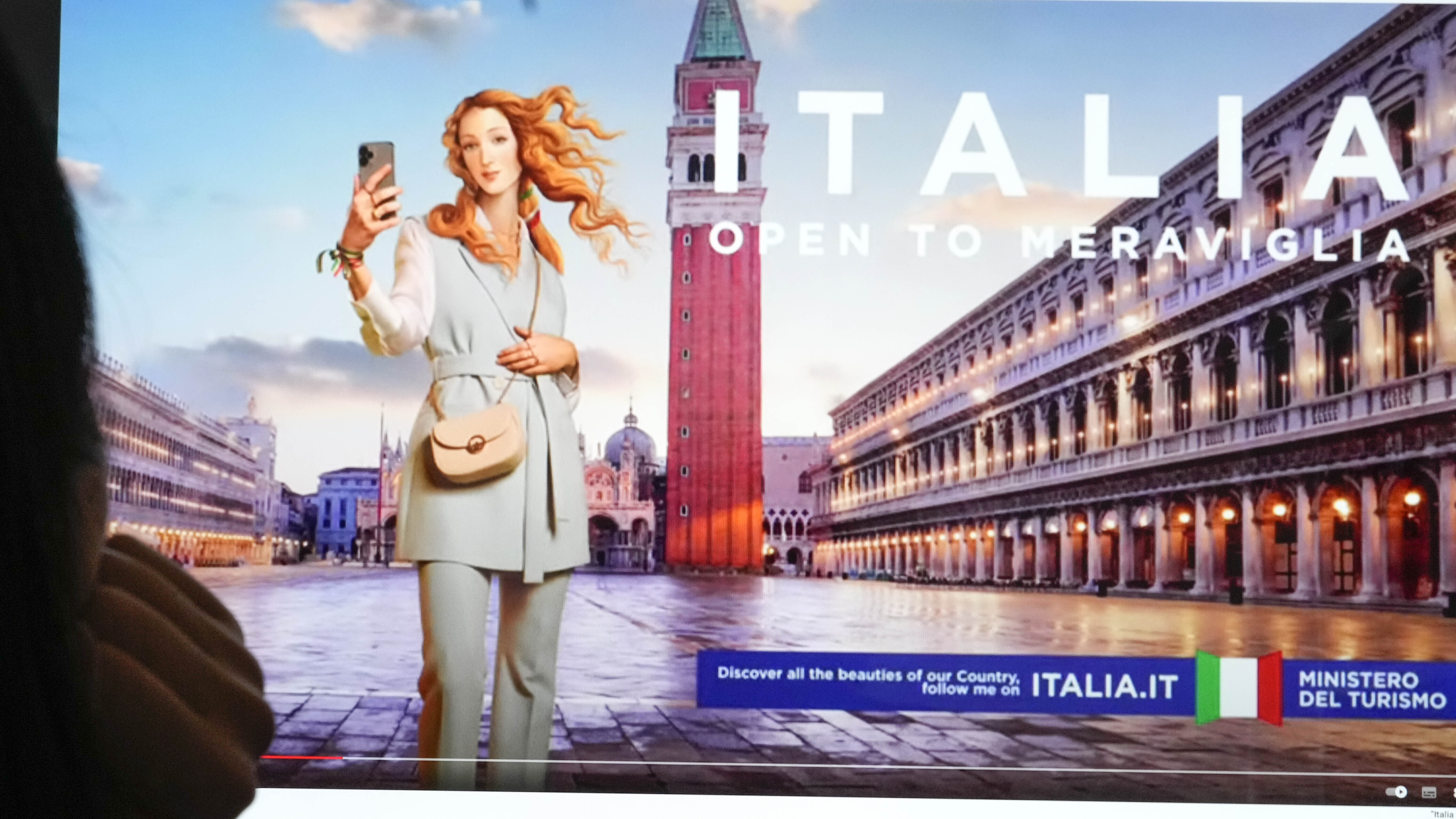 Unas personas observan un monitor con una campaña publicitaria del Ministerio de Turismo de Italia que muestra una versión digitalizada, y vestida, de la Venus del pintor renacentista Sandro Botticelli (AP Foto/Gregorio Borgia)
