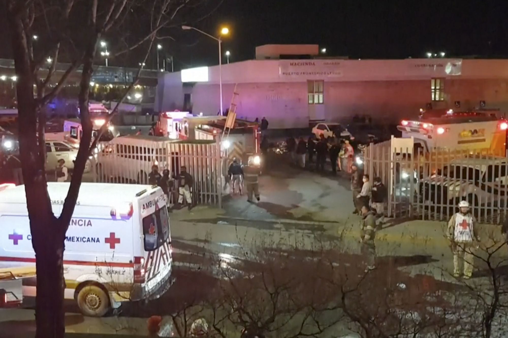 Esta imagen extraída de un video muestra ambulancias y equipos de emergencias ante un centro migratorio en Ciudad Juárez. (AP Foto)