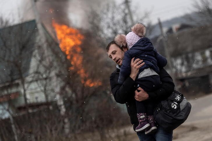 Un hombre y un bebpe escapan de los bombardeos en la localidad de Irpín, cercana a Kiev, Ucrania. 6 marzo 2022. REUTERS/Carlos Barría
