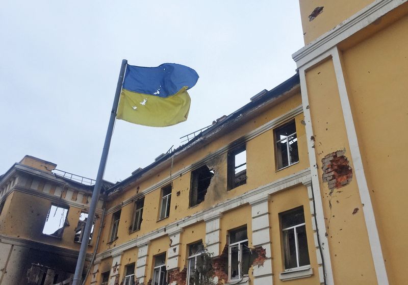 La bandera de ucraniana, delante de una escuela que, según residentes locales, estaba en llamas después de los bombardeos, mientras la invasión rusa de Ucrania continúa, en Jarkov, Ucrania (REUTERS/Vitaliy Gnidyi)