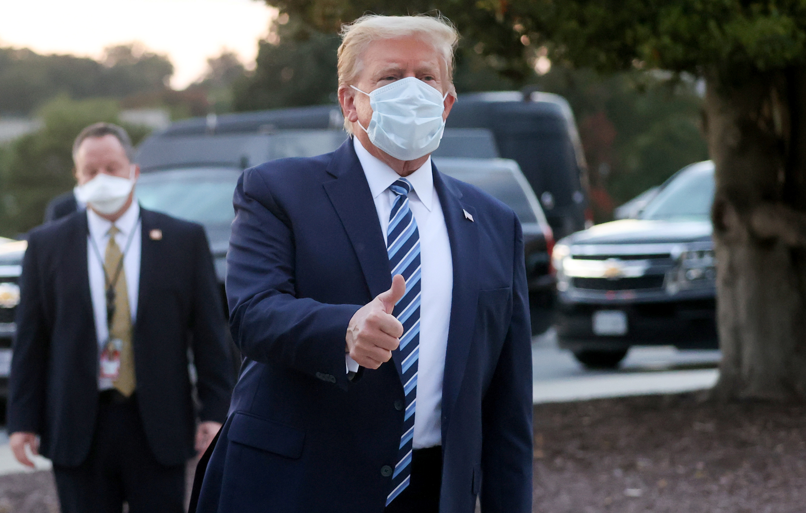 US President Donald Trump takes off his facemask as he arrives at the White House upon his return from Walter Reed Medical Center, where he underwent treatment for Covid-19, in Washington, DC, on October 5, 2020. (Photo by NICHOLAS KAMM / AFP)