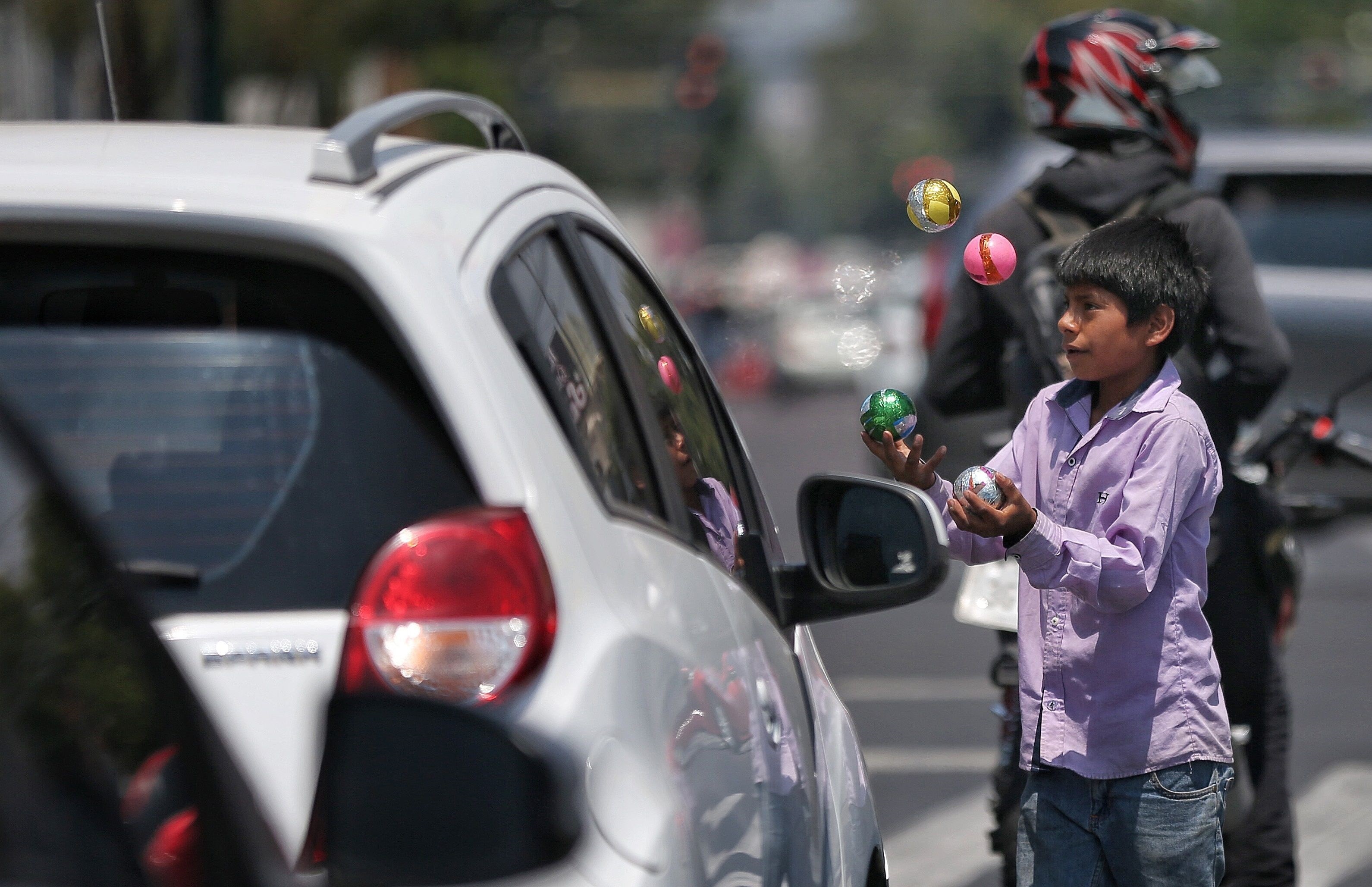 Un niño realiza malabares entre las filas de vehículos el miércoles 10 de junio de 2020, en Ciudad de México (México). EFE/Sáshenka Gutiérrez
