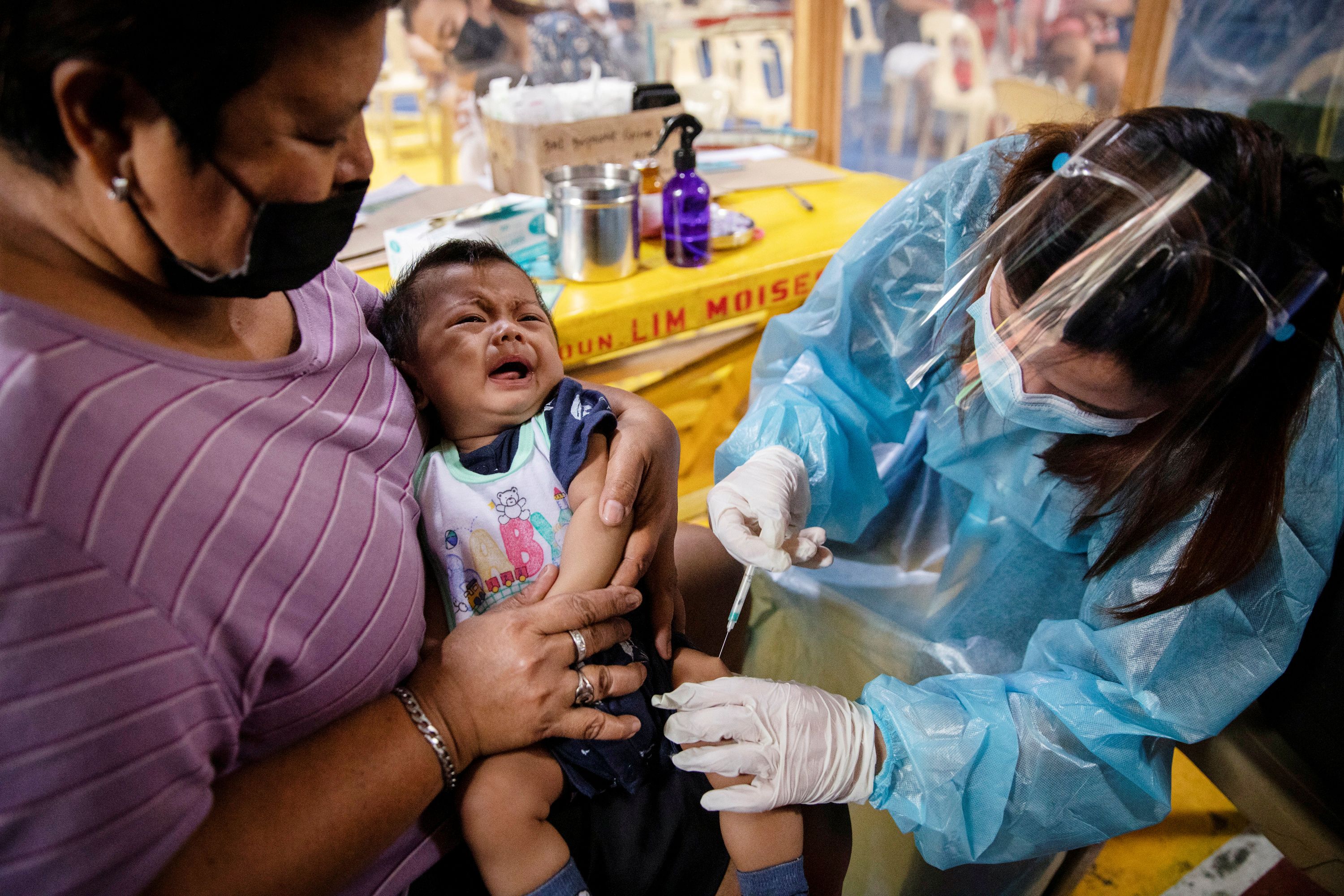 Una enfermera con equipo de protección personal administra las vacunas de rutina a un bebé en Manila, Filipinas, el 27 de enero de 2021 (REUTERS/Eloisa López)