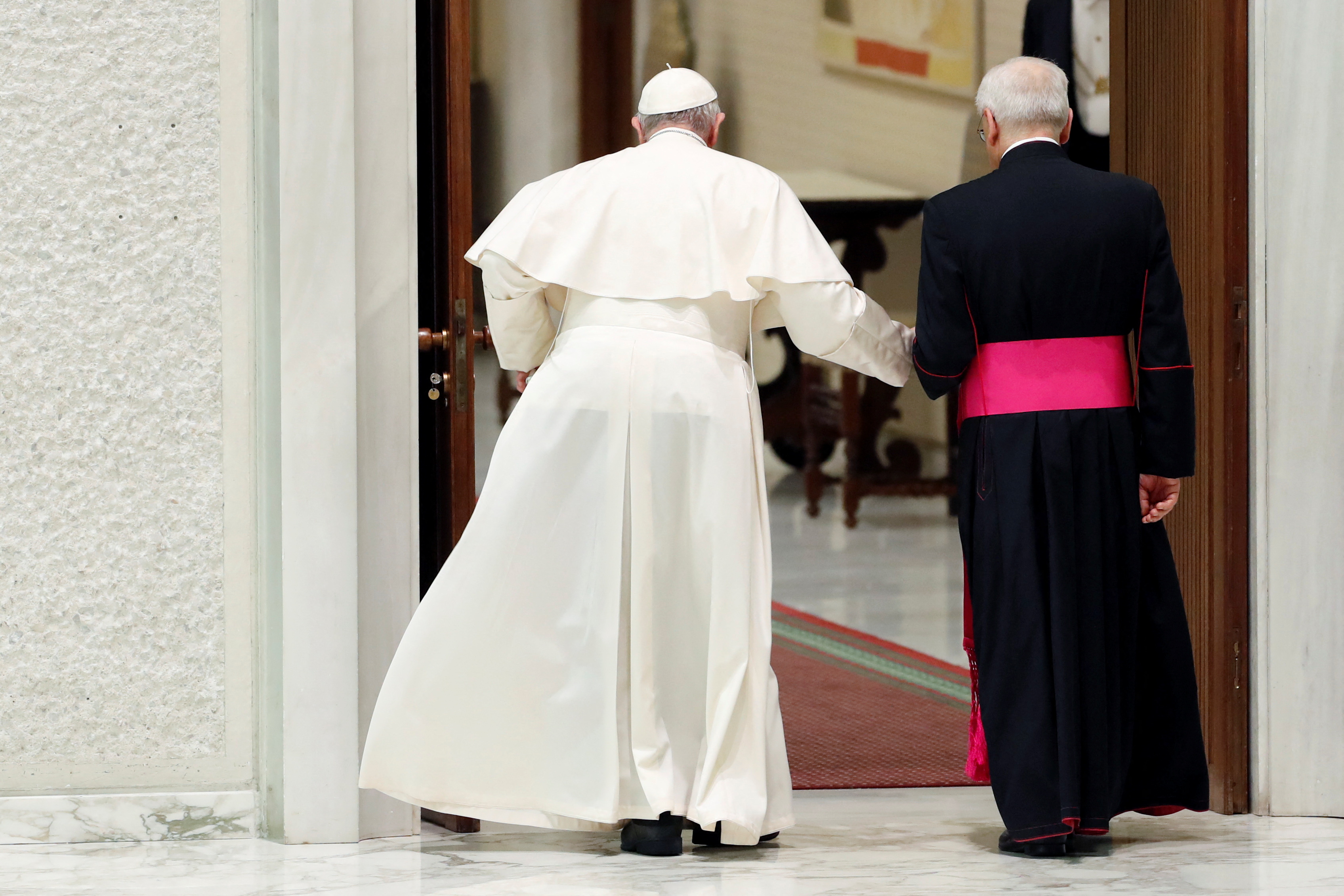 El papa Francisco caminando con la ayuda de un colaborador (REUTERS/Remo Casilli)