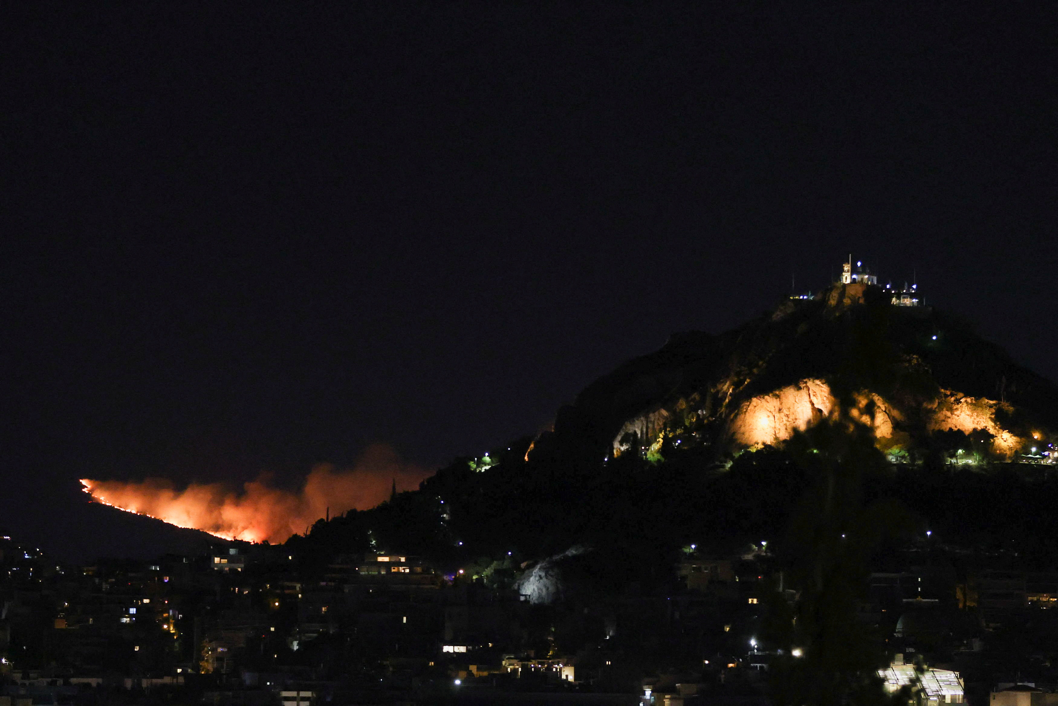 El fuego se ve detrás de la colina Lycabettus  (REUTERS/Stelios Misinas)