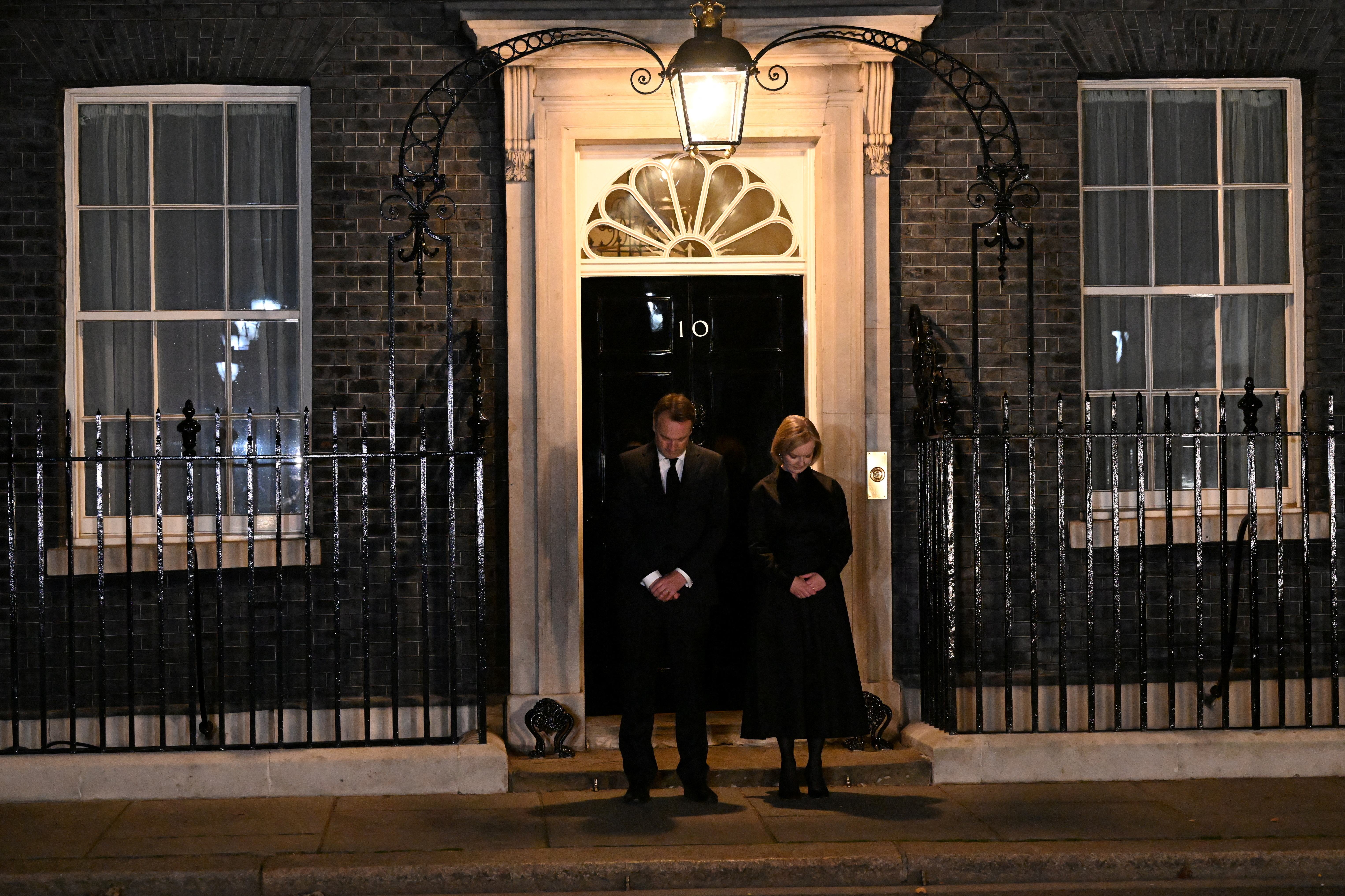 La primera ministra británica, Liz Truss, y su marido, Hugh O'Leary, guardan un minuto de silencio en el número 10 de Downing Street,