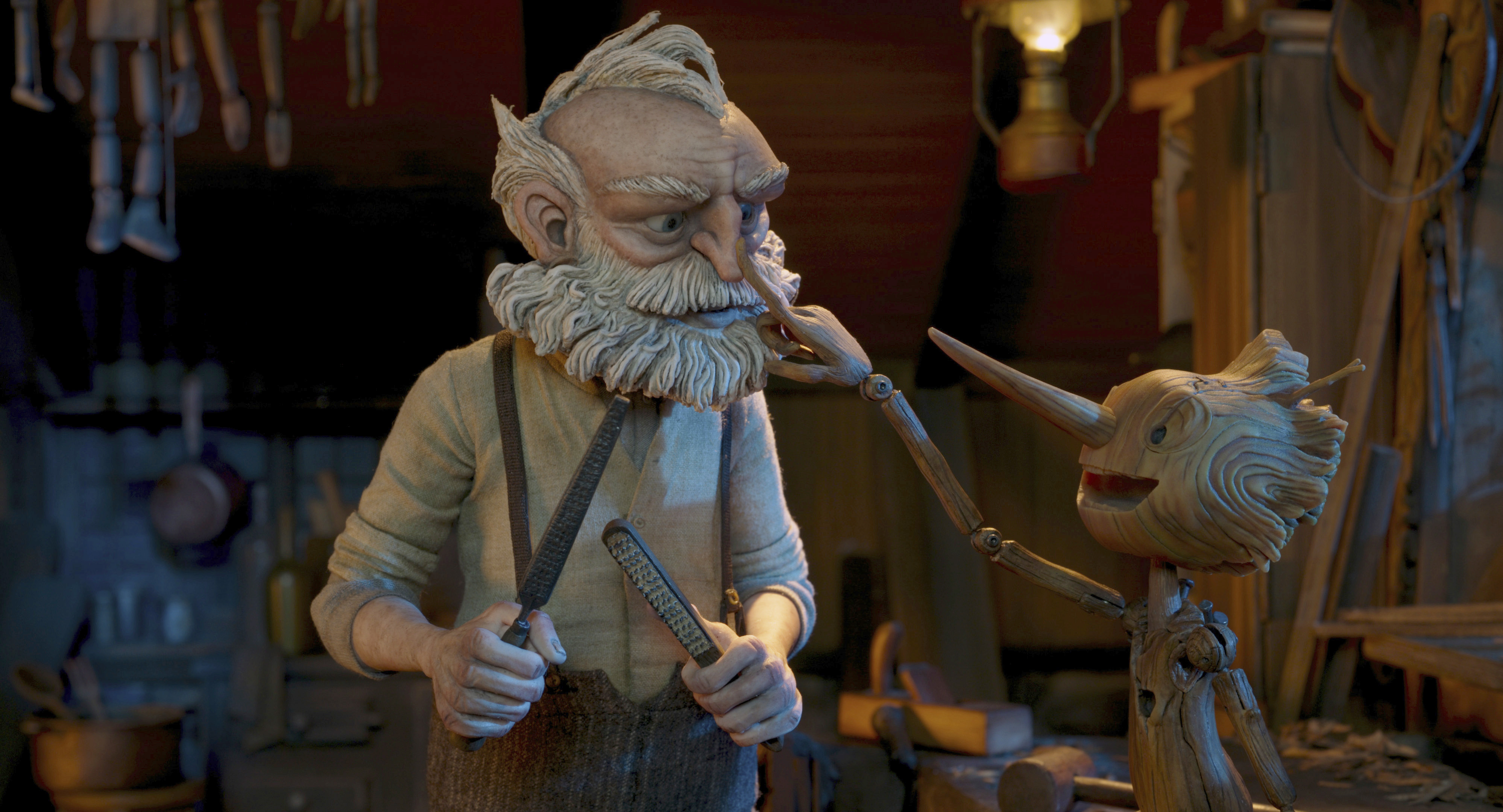 Gepetto, con la voz de David Bradley en la versión original en inglés (izquierda), y Pinocho, en una escena de la película de Guillermo del Toro (Foto: Netflix vía AP)
