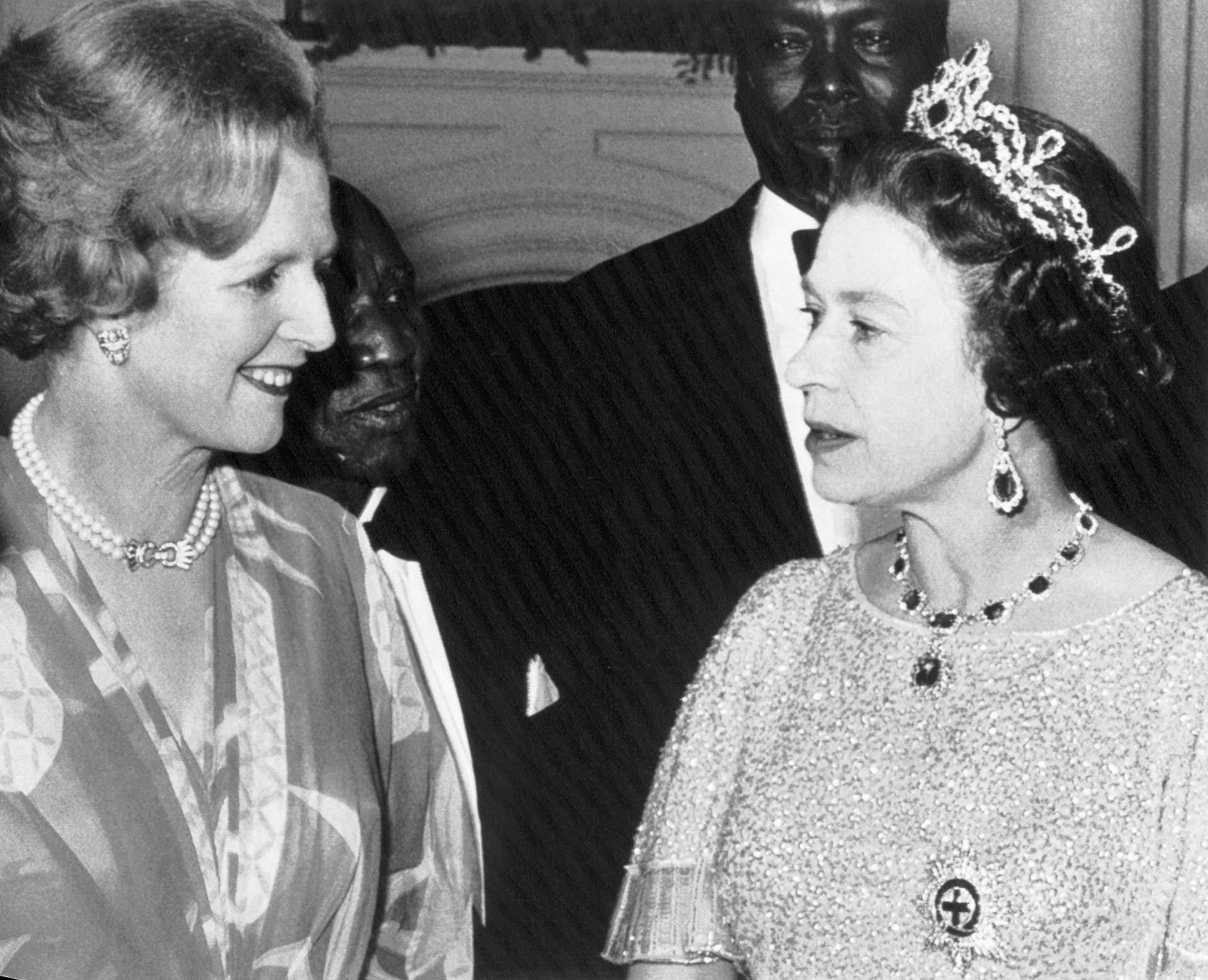 Lusaka, Zambia- La Primera Ministra británica, Margaret Thatcher (izquierda), y la Reina Isabel, conversan en una fiesta para los Jefes de Estado reunidos aquí para la Conferencia de la Commonwealth. Mirando en la parte trasera están; Dr. Hasting Banda (izquierda) de Malawi y Arap Moi de Kenia