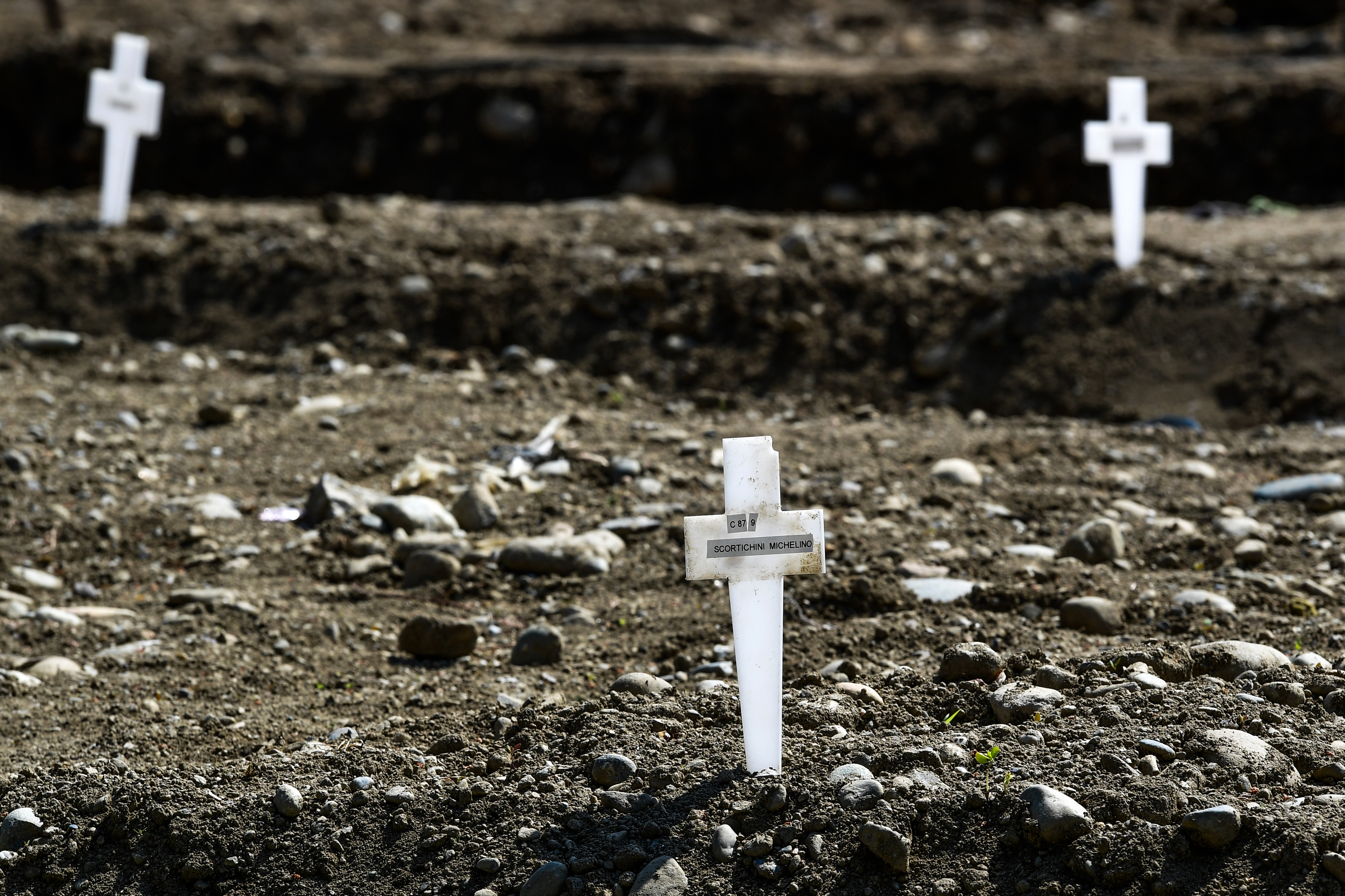 Una vista muestra cruces en el área llamada Campo 87, donde unos 60 cuerpos no reclamados, de personas que murieron por coronavirus, han sido enterrados hasta ahora por el municipio en el cementerio Maggiore en Milán (Foto por Miguel MEDINA / AFP)