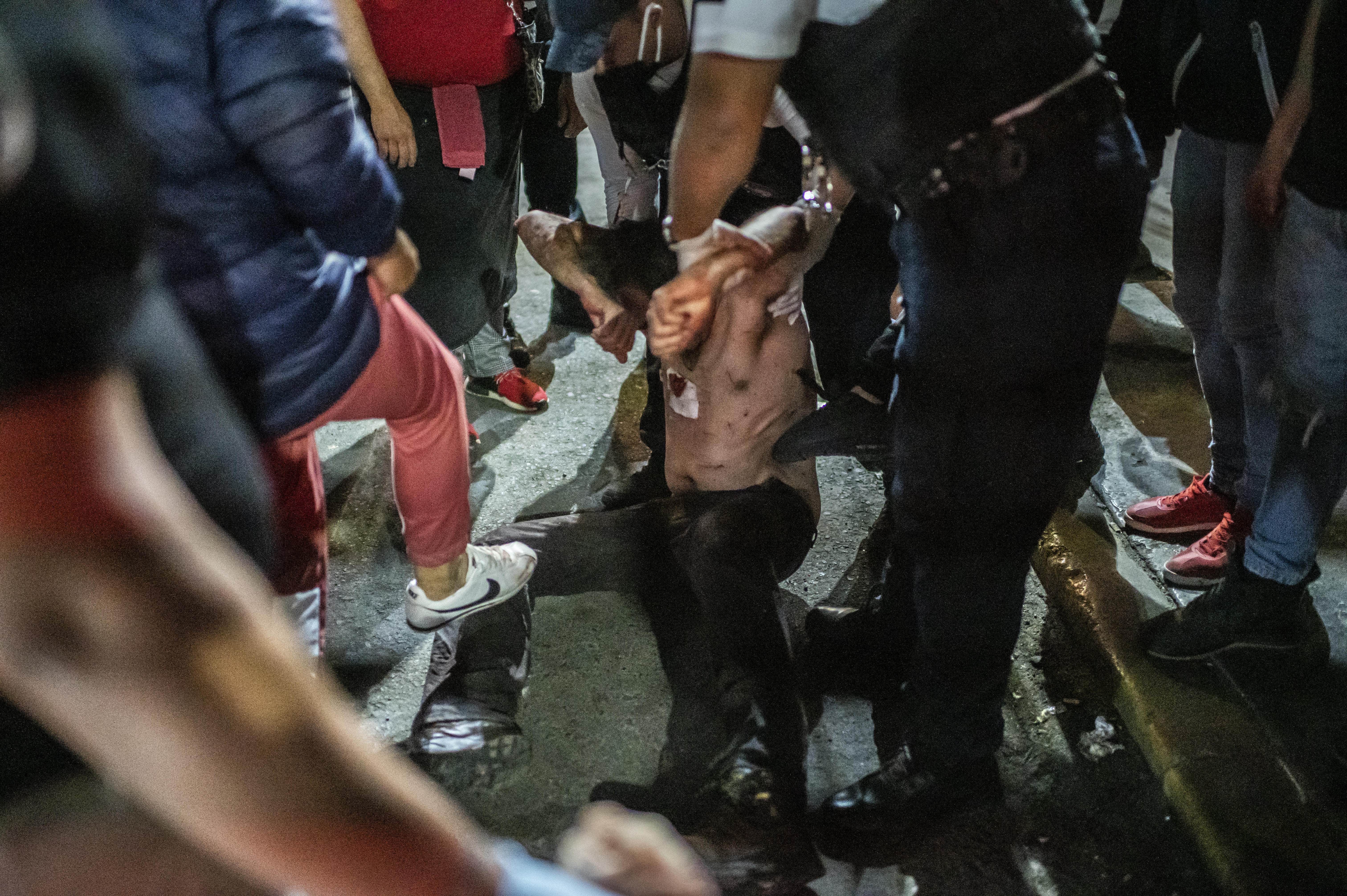 La gente golpea a un hombre acusado de atacar a su madre, en Ciudad Nezahualcóyotl, Estado de México, México, el 20 de junio de 2020, durante la nueva pandemia de coronavirus de COVID-19. (Foto por Pedro PARDO / AFP)