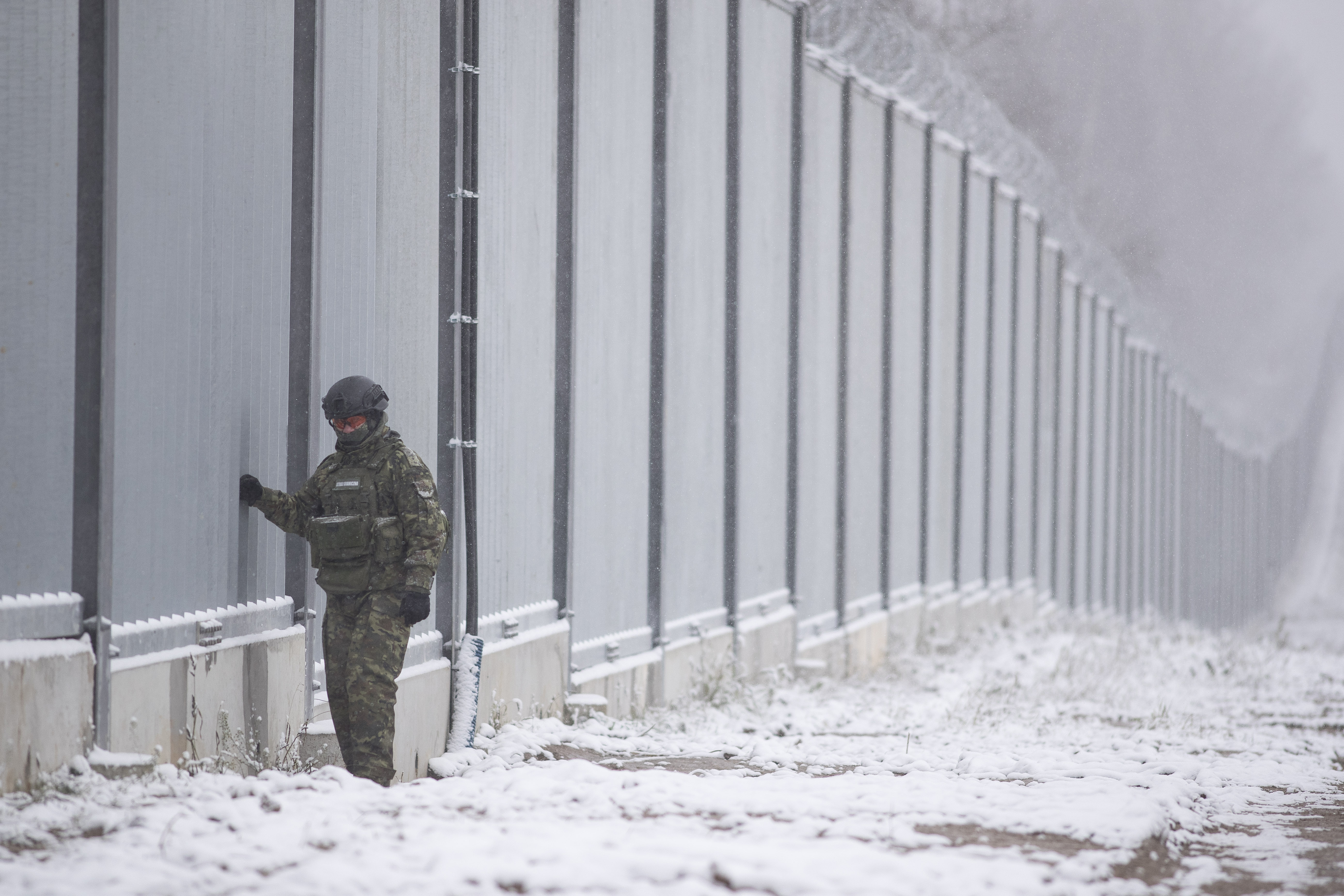 Polski strażnik graniczny stoi przy murze granicznym w Nomikach, Polska, piątek, listopad 2022 r. (AP Photo/Maciek Łuczniewski)