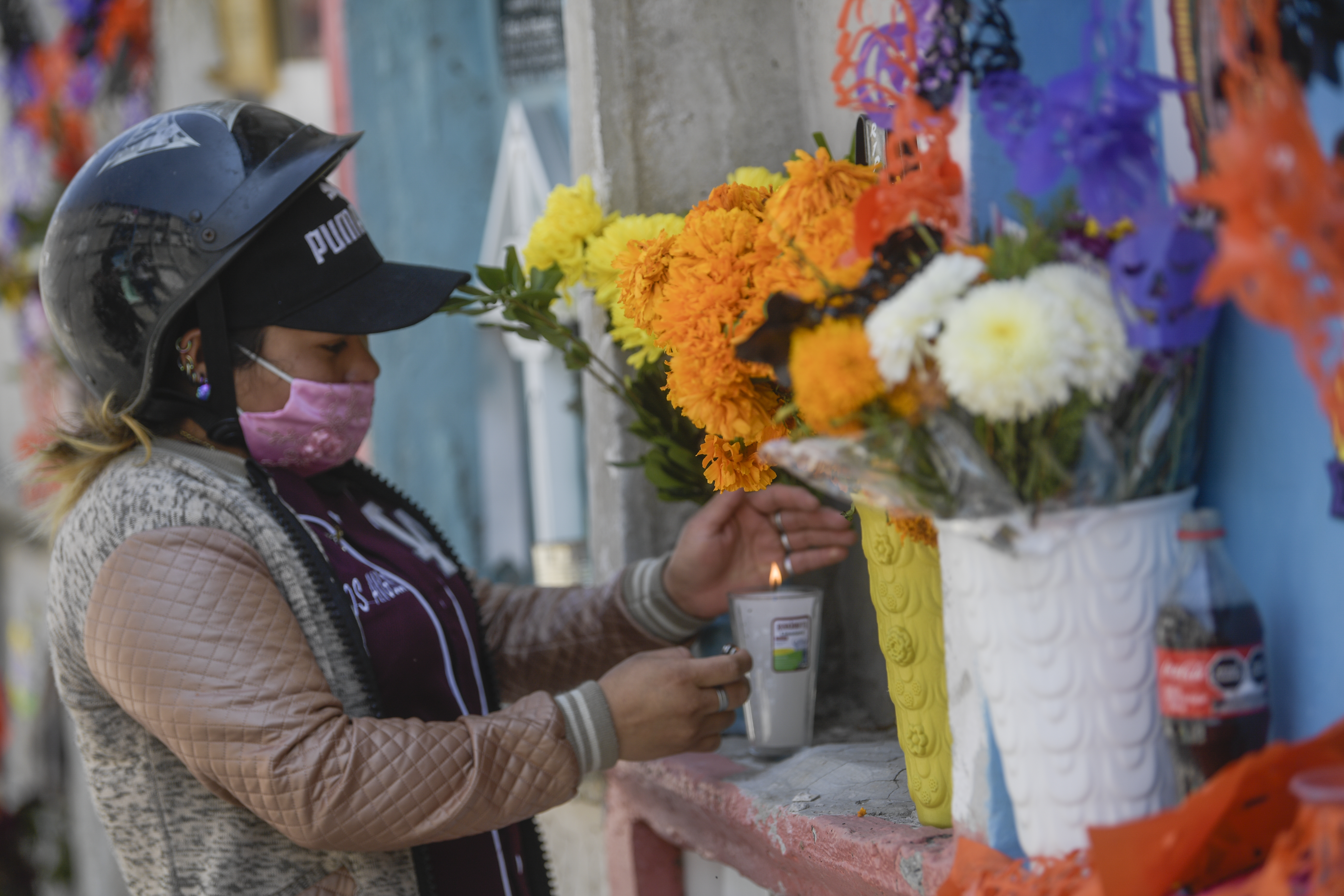 Una mujer decora la tumba de un familiar antes del Día de Muertos en el panteón municipal de Nezahualcóyotl, México, el 28 de octubre de 2020, en medio de la pandemia del coronavirus COVID-19.