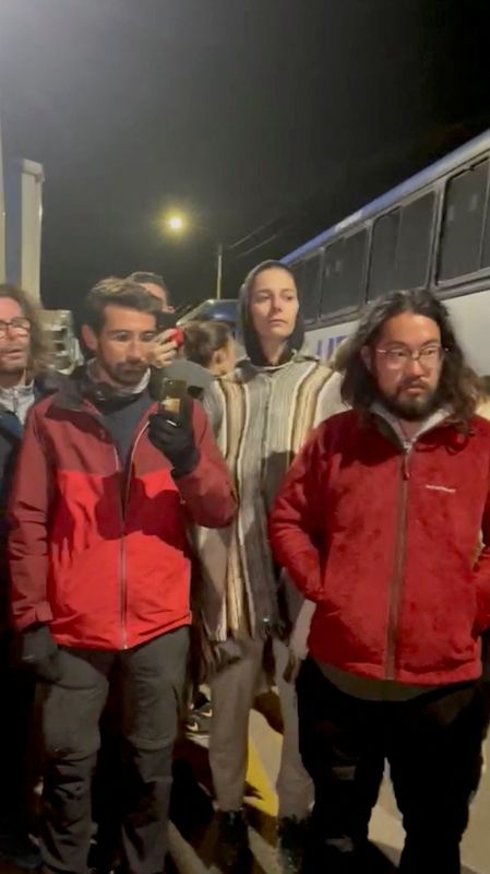 Turistas de pie junto a un autobús mientras estaban bloqueados por las protestas, en Checacupe, región de Cusco, Perú, el 13 de diciembre de 2022,  imagen obtenida de un vídeo en redes sociales. Wilmaris Villarroel/via REUTERS