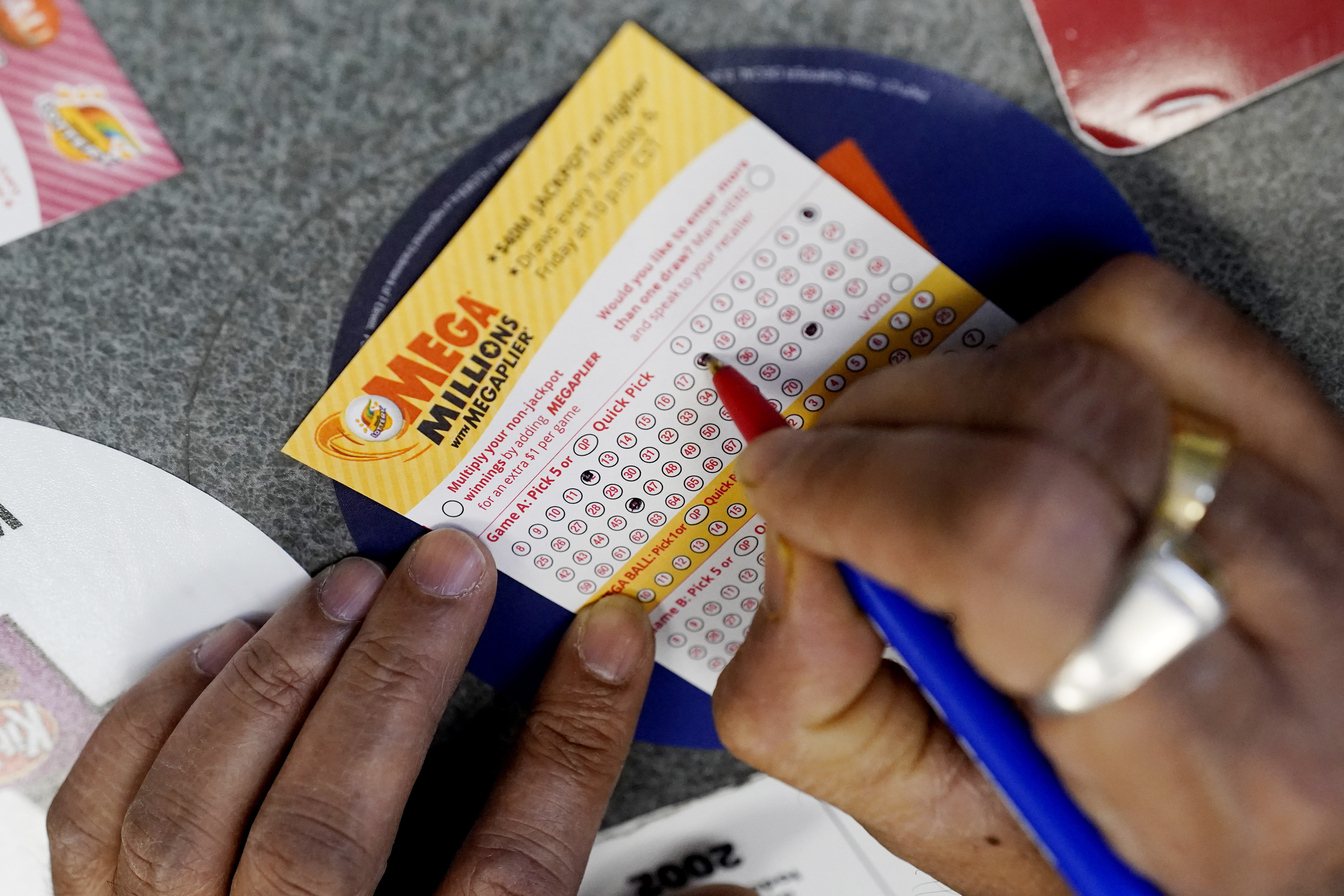 A customer fills out a Mega Millions lottery ticket at a convenience store in Northbrook, Illinois.  (AP Photo/Nam Y. Huh, File)