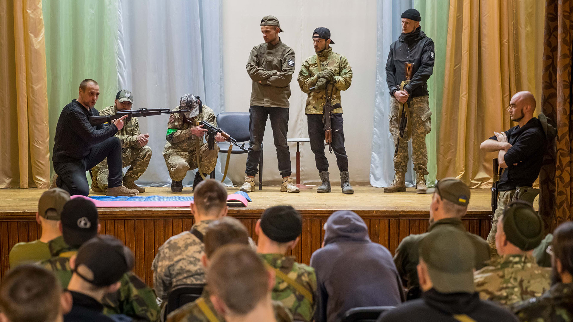 Un veterano de guerra que les enseña a manejar una AK-47, a cómo tomar aire antes de disparar o a qué hacer al entrar en combate dentro de un edificio. EFE/ Miguel Gutiérrez
