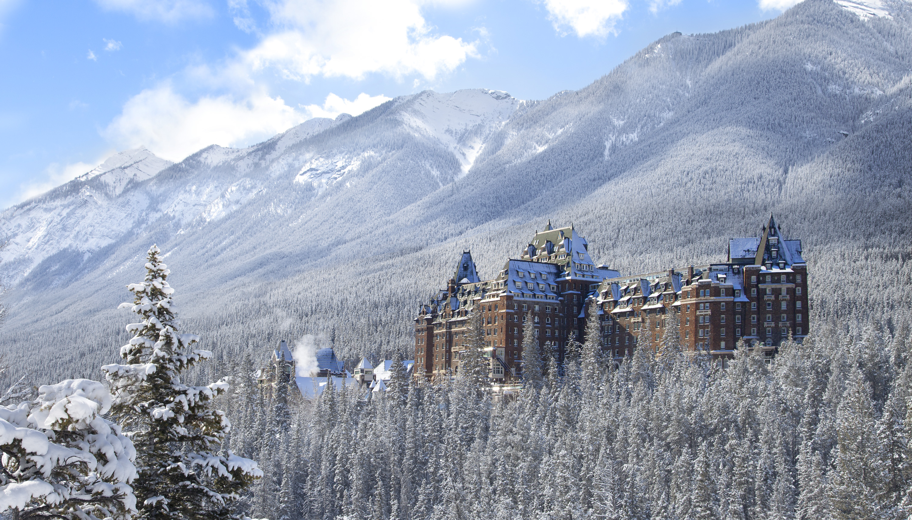 Una postal del hotel de lujo Fairmont Banff Springs, un enorme castillo en medio de las montañas blancas (crédito Travel Alberta)