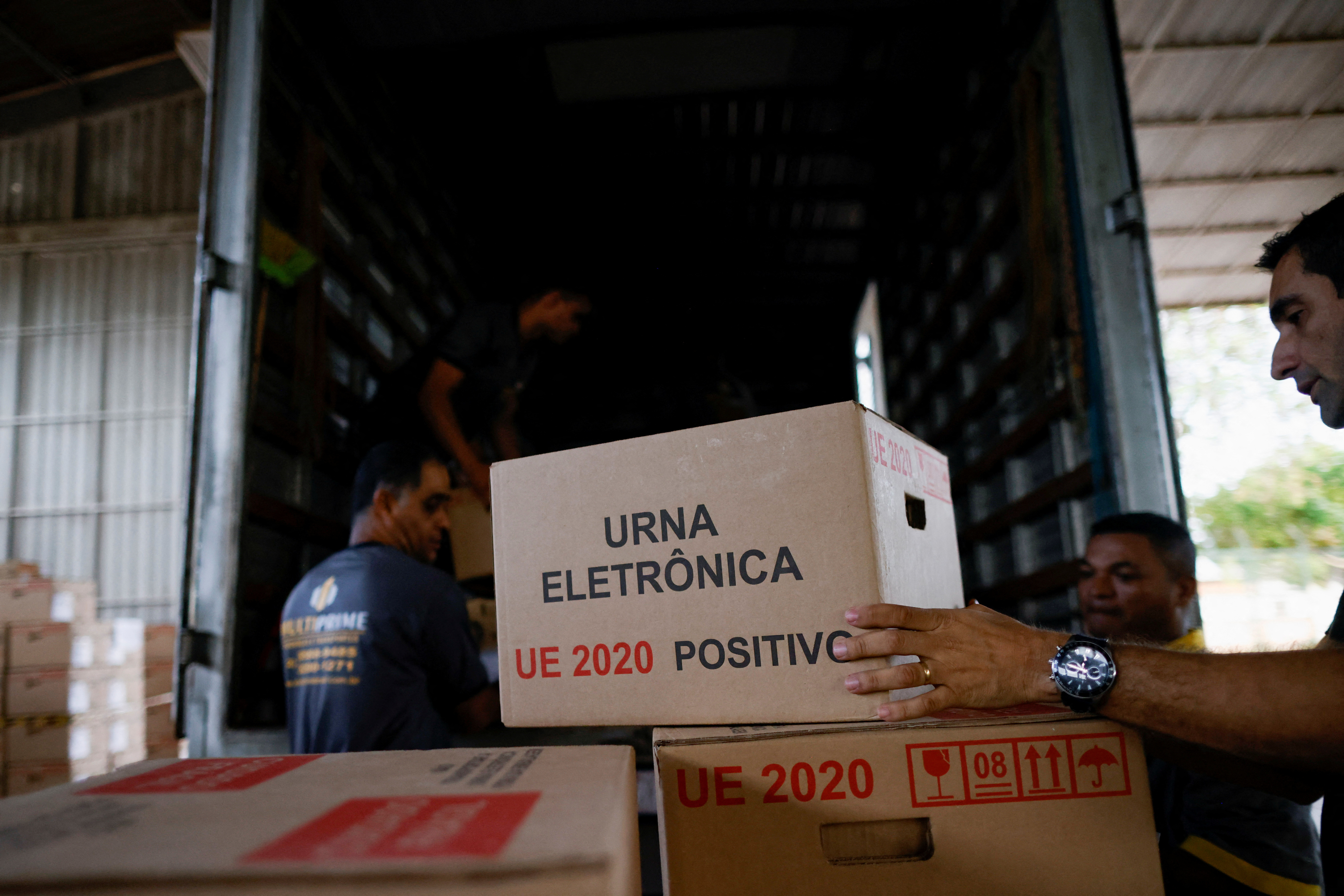 Empleados cargan un camión con las máquinas de voto electrónico que se utilizarán para votar en la primera vuelta de las próximas elecciones presidenciales brasileñas, en Brasilia (REUTERS/Adriano Machado)