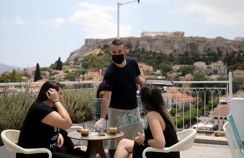 Foto de archivo ilustrativa de un mozo atendiendo al público en una cafetería de Atenas, con la Acrópolis de fondo. 
May 25, 2020. REUTERS/Costas Baltas